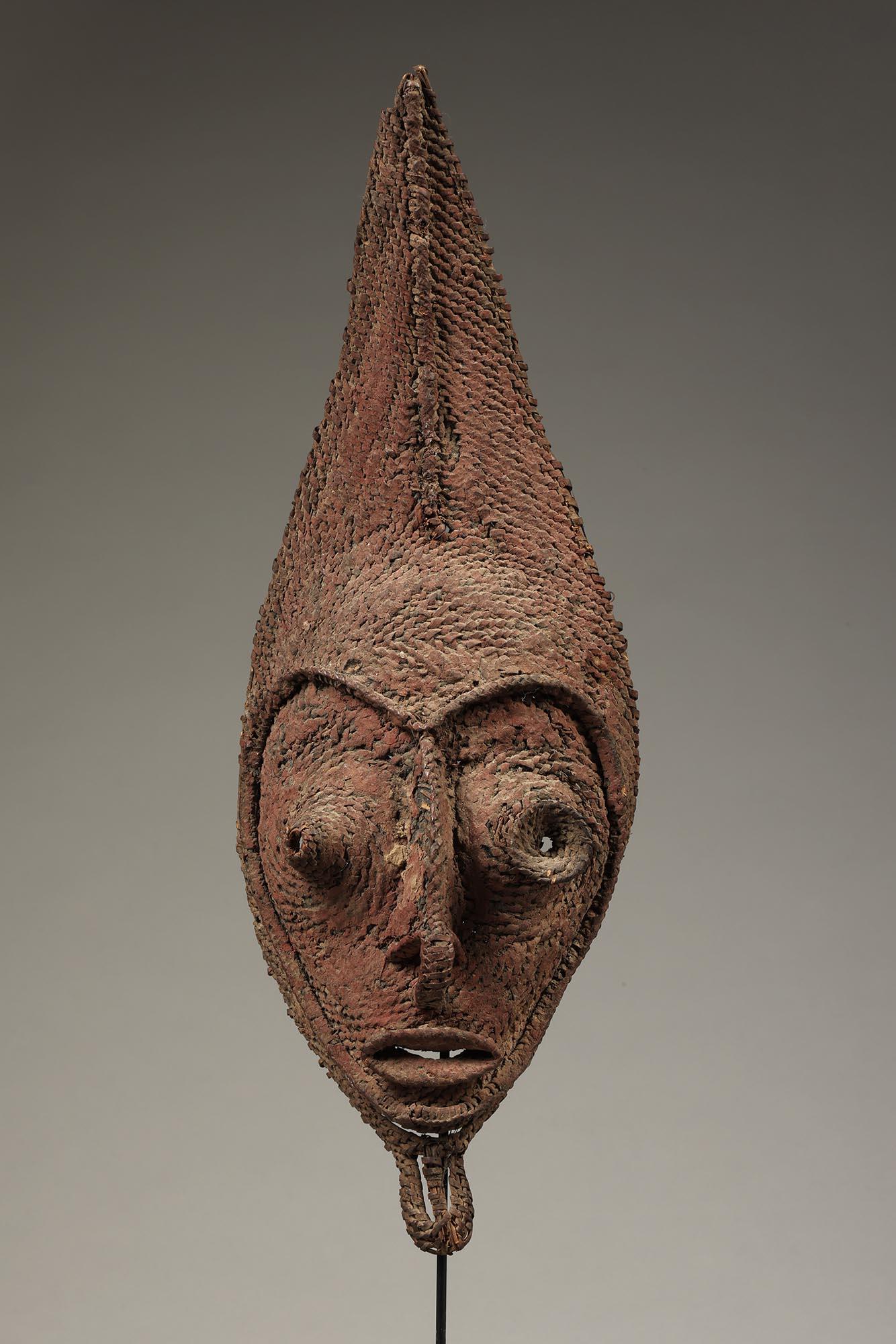 Early Papua New Guinea Sepik tightly woven raffia mask from a talipun bride price currency piece.  Old very encrusted surface.
Areas of red and other pigments. Wonderful heart shaped face with open eyes and mouth. One eye with projecting disc.
This