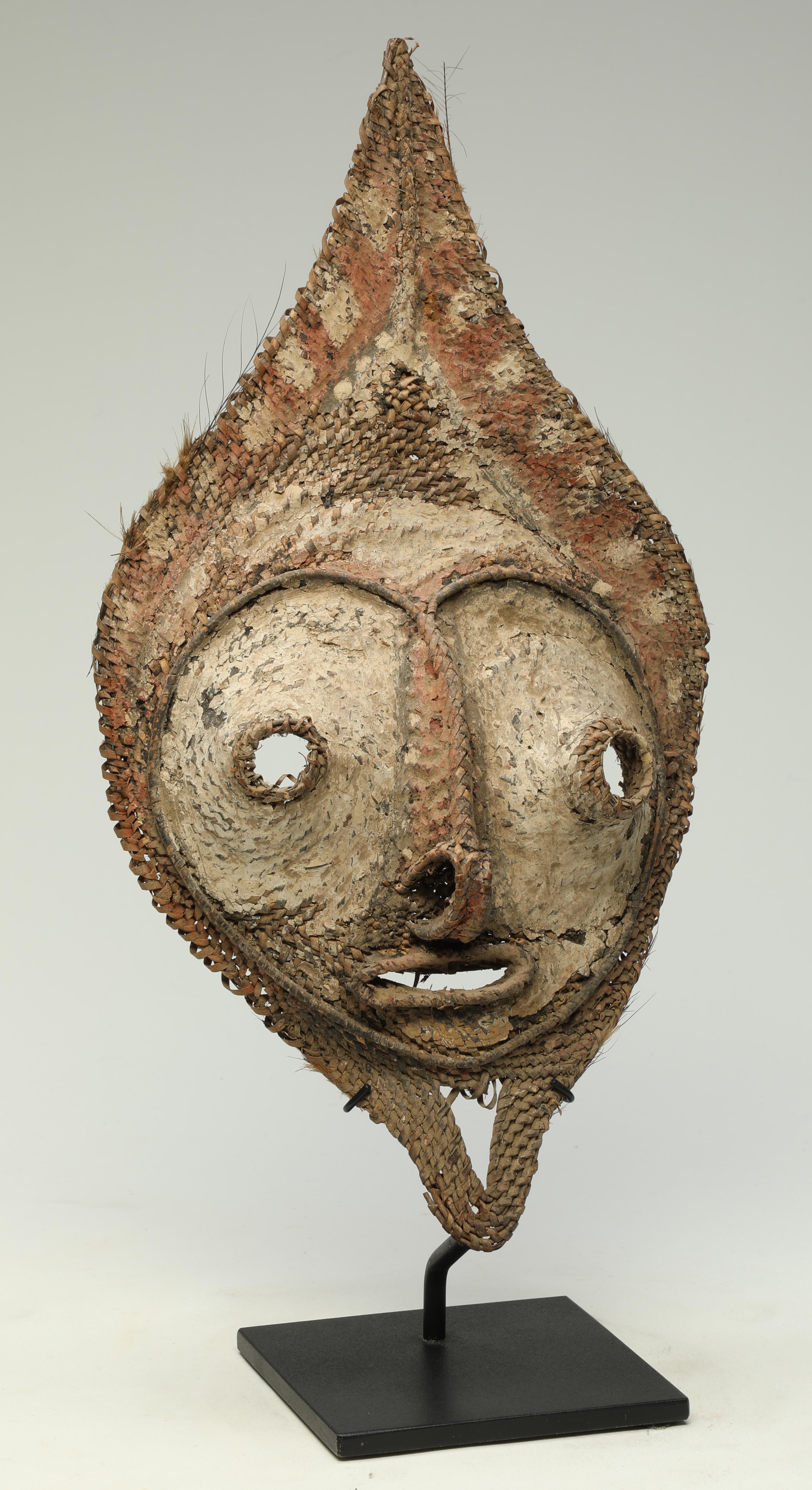 Early Papua New Guinea Sepik tightly woven raffia mask from a talipun bride price currency. 
Areas of white, black and red pigments. Wonderful heart shaped face with open eyes and mouth.
This mask or face would have been tied to a large shell which
