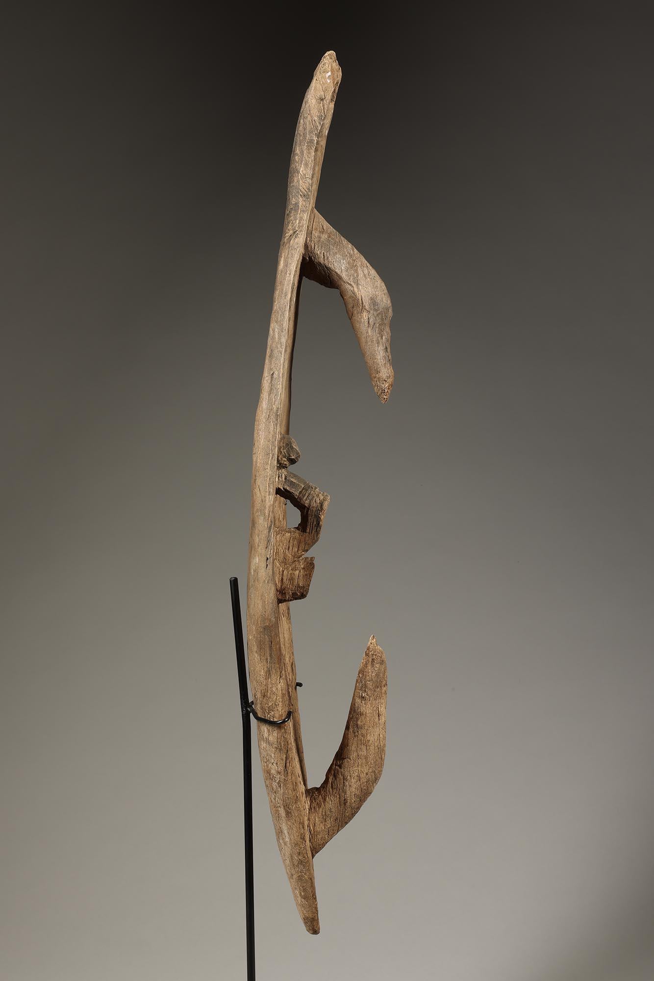 Early Papua New Guinea abstract hook figure or mask with two opposing hooks, and central looped design, Sepik River area. Some chips missing to central loops. Small hole at top for suspension.  Overall weathered eroded surface.  Pieces like this