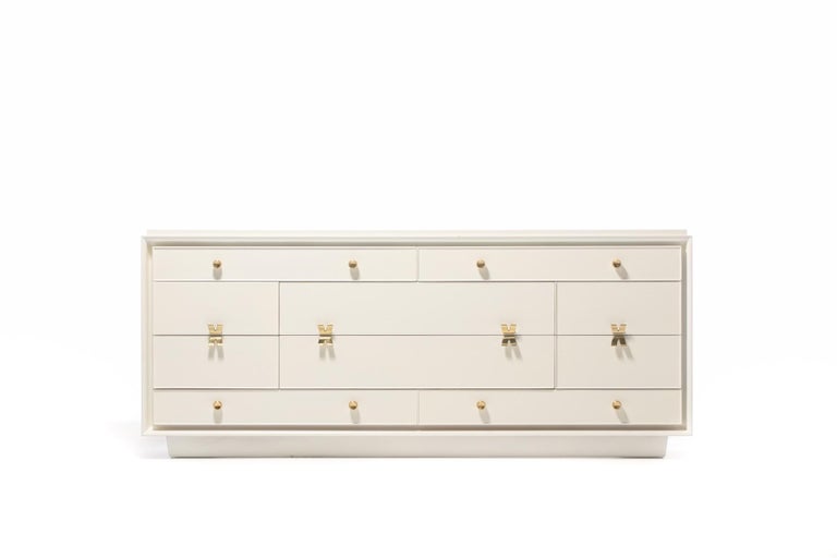 Exceptionally rare early 1940s Paul Frankl dresser or side board professionally refinished in white chocolate with original polished brass hardware. A predecessor to the more common Paul Frankl X pull dresser, this dresser features 10 drawers in