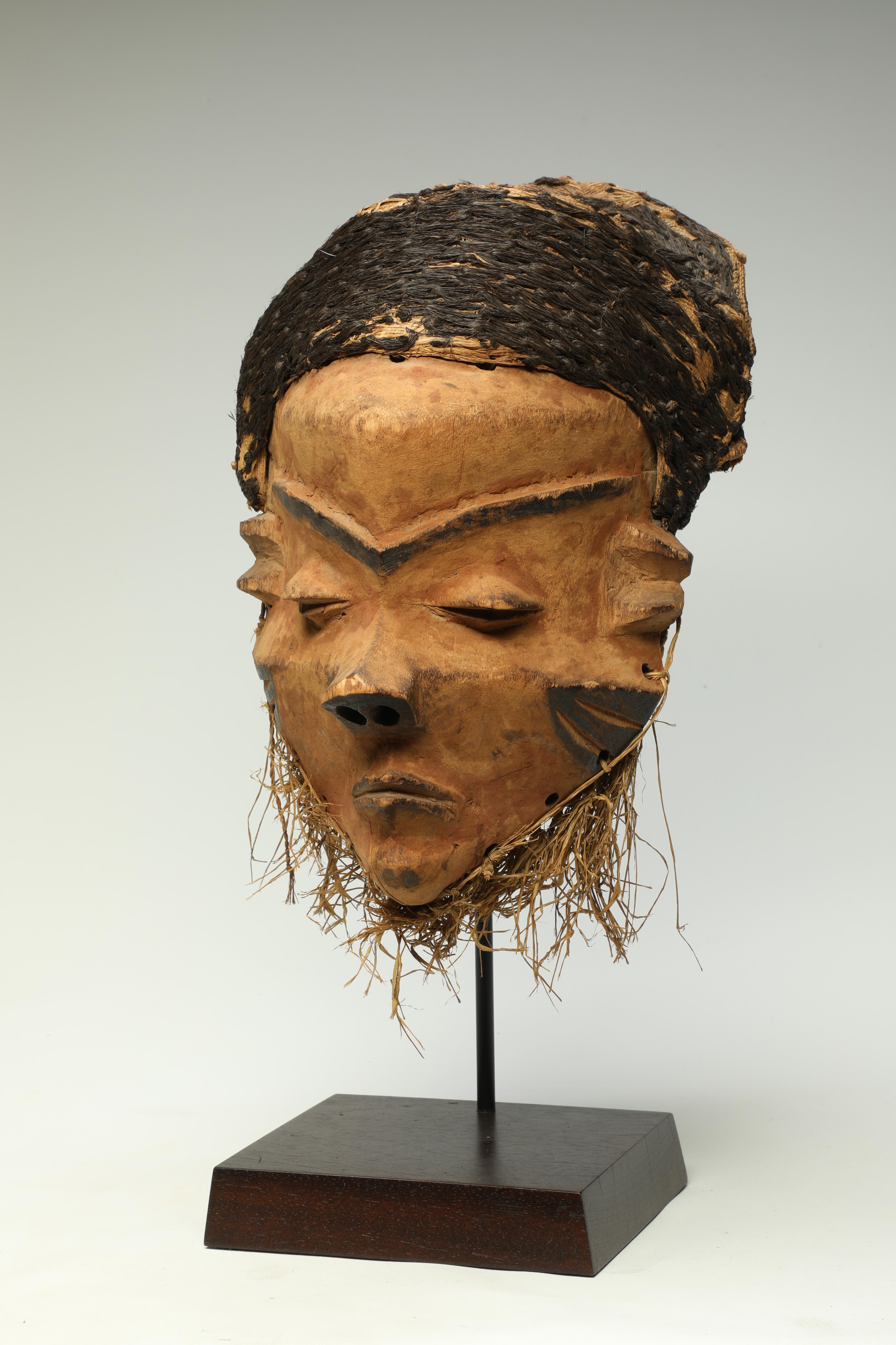 Old Pende giwoyo mask with traces of pigments, black and red and woven black raffia hair cap. Strong face with tight expression, weathered surface, good age. From private collection, Germany.
The mask is 12 inches high, on custom wood base total