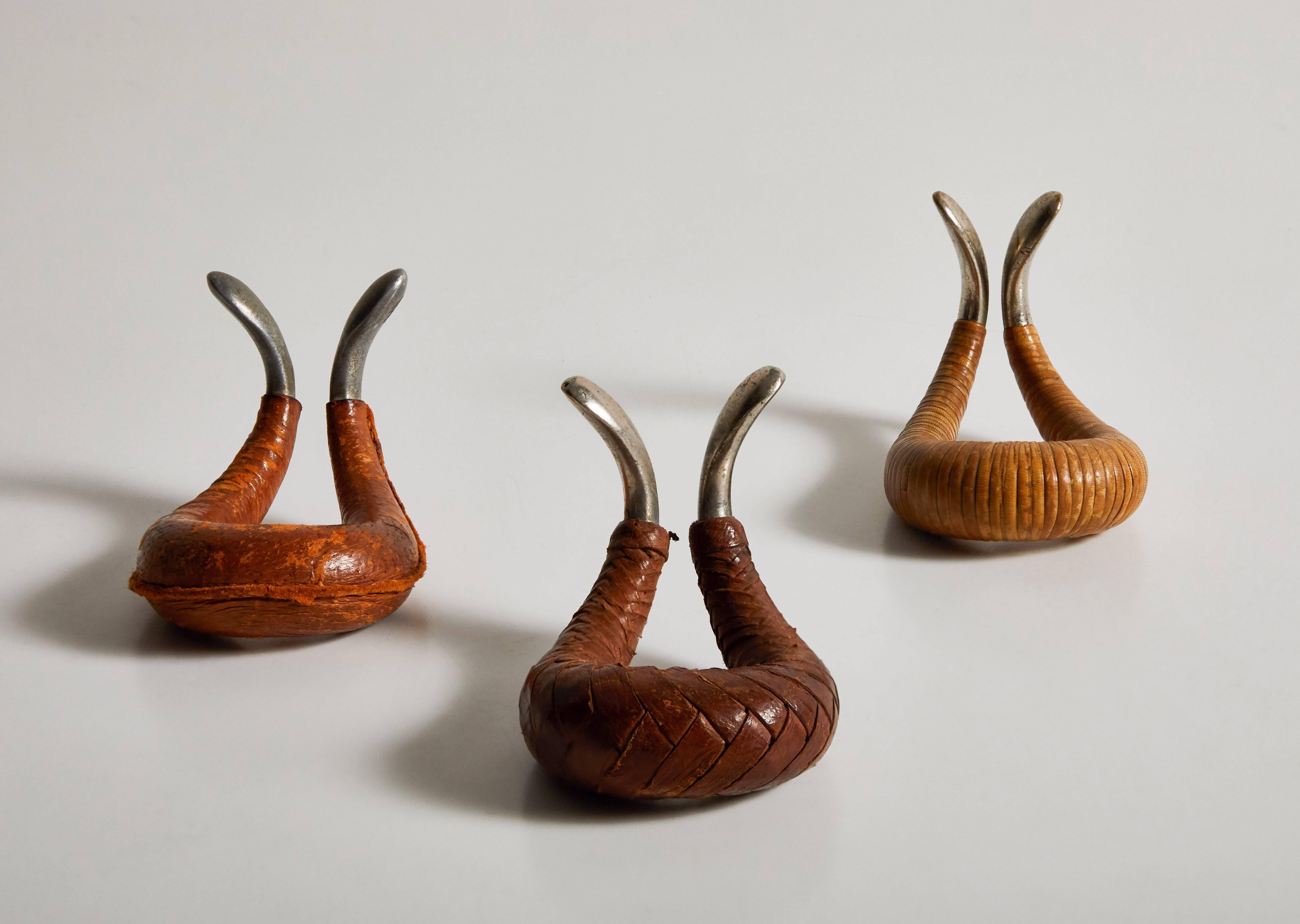 Leather wrapped and cast aluminium pipe rests by Carl Auböck. Made in Austria, circa 1950s.