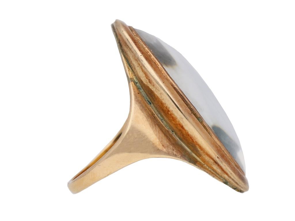 Early portrait miniature memorial ring. Vertically set with an oval portrait miniature of a lady in late eighteenth century period dress wearing a floral hat on a blue ground, covered with a convex glass in a closed back collet setting, within a
