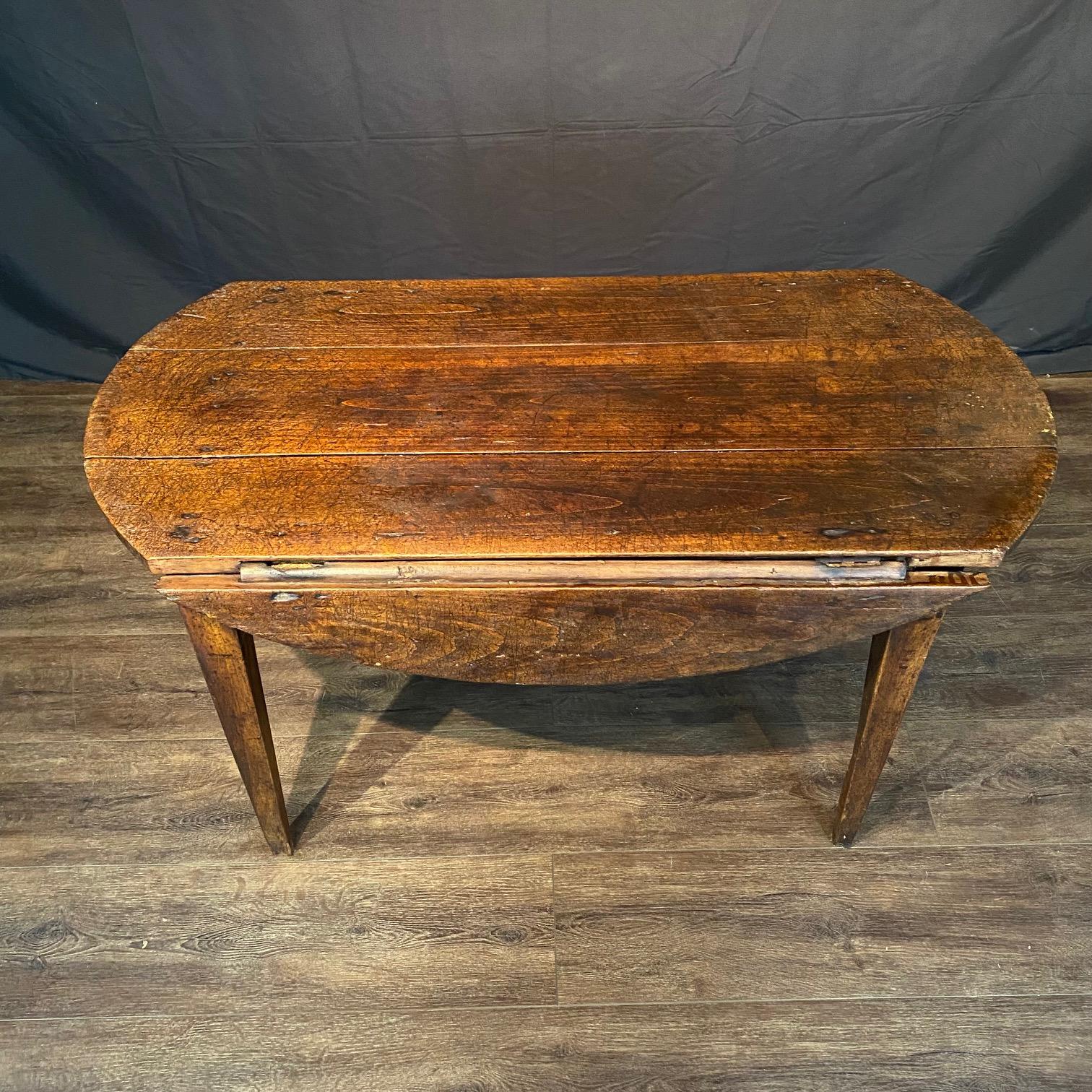 French 18th century oval country drop leaf table. Glorious color with lots of character! Lovely gently tapered legs and all original hinges which support the level table top. Will add charm and interest to any room.  From the South of France in