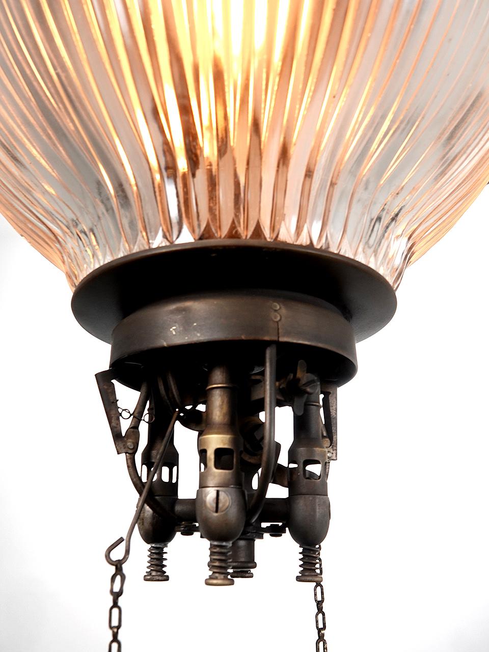 This is one of the more interesting industrial style lamps. The body is copper topped by a cast iron crown. Above that are two street light style electrical pickups in copper and white ceramic. The shade is a large 20 inch diameter with a green over