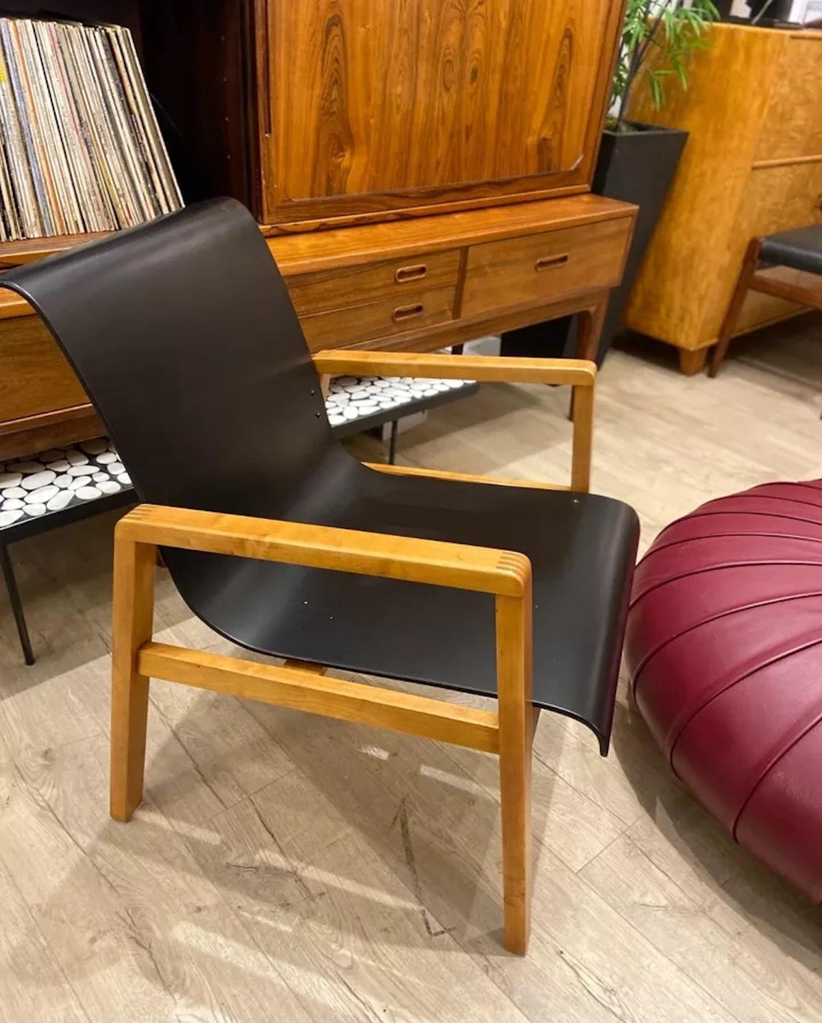 This exceptionally rare early production Alvar Aalto Hallway Chair, model 403, was designed for Finmar and showcases Aalto’s iconic use of bent ply seating on a solid birch frame with inlaid arm details. In original vintage condition, this chair