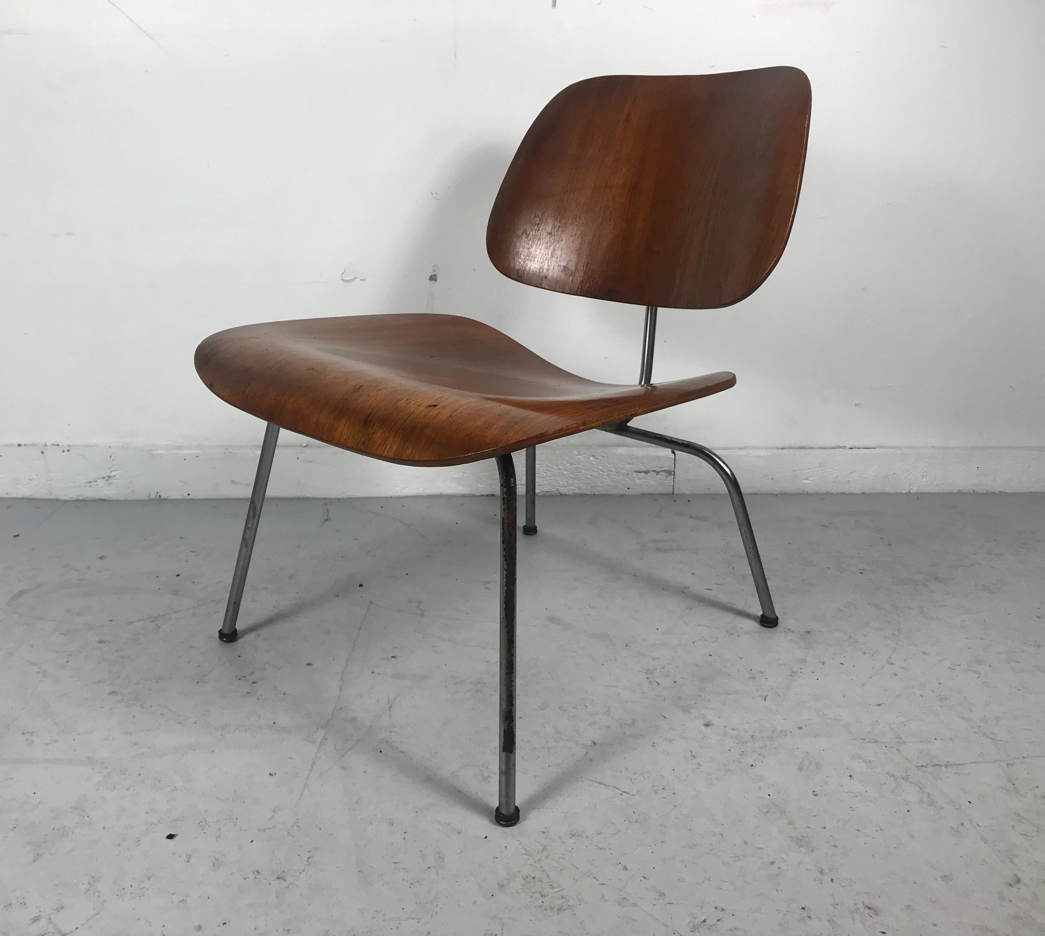 Nice early example, 50-51. Plywood and metal lounge chair designed by Charles and Ray Eames for Herman Miller, chair retains its original label, developmental mounts, domes of silence feet. Nice original condition, chromed frame showing signs of