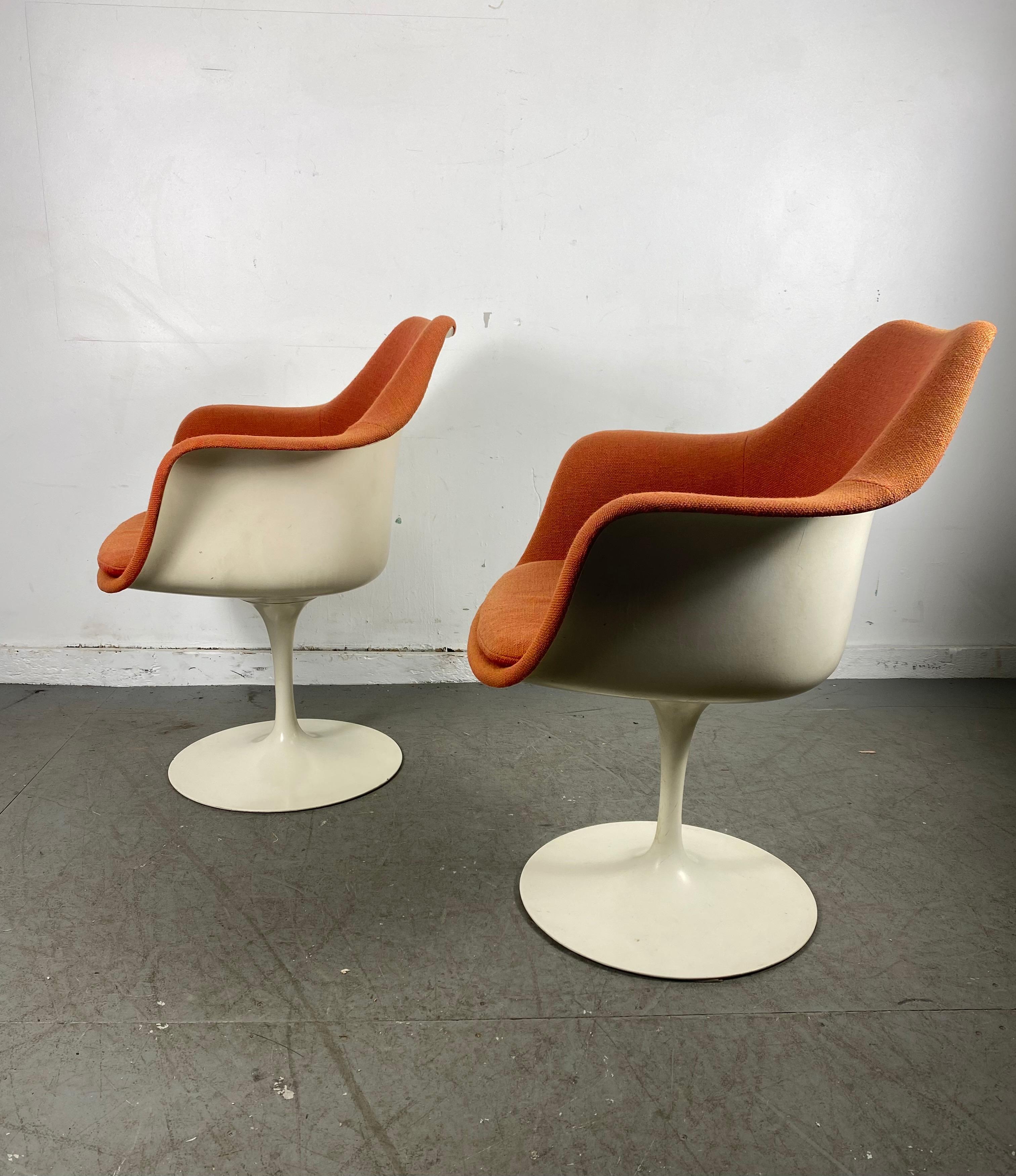 Seldom seen pair of Eero Saarinen upholstered Tulip arm chairs manufactured by Knoll. Retain original orange knoll fabric, also retains early Knoll labels, nice original condition, minor blemishes to seat pads (see photo) also minor fading to arms.