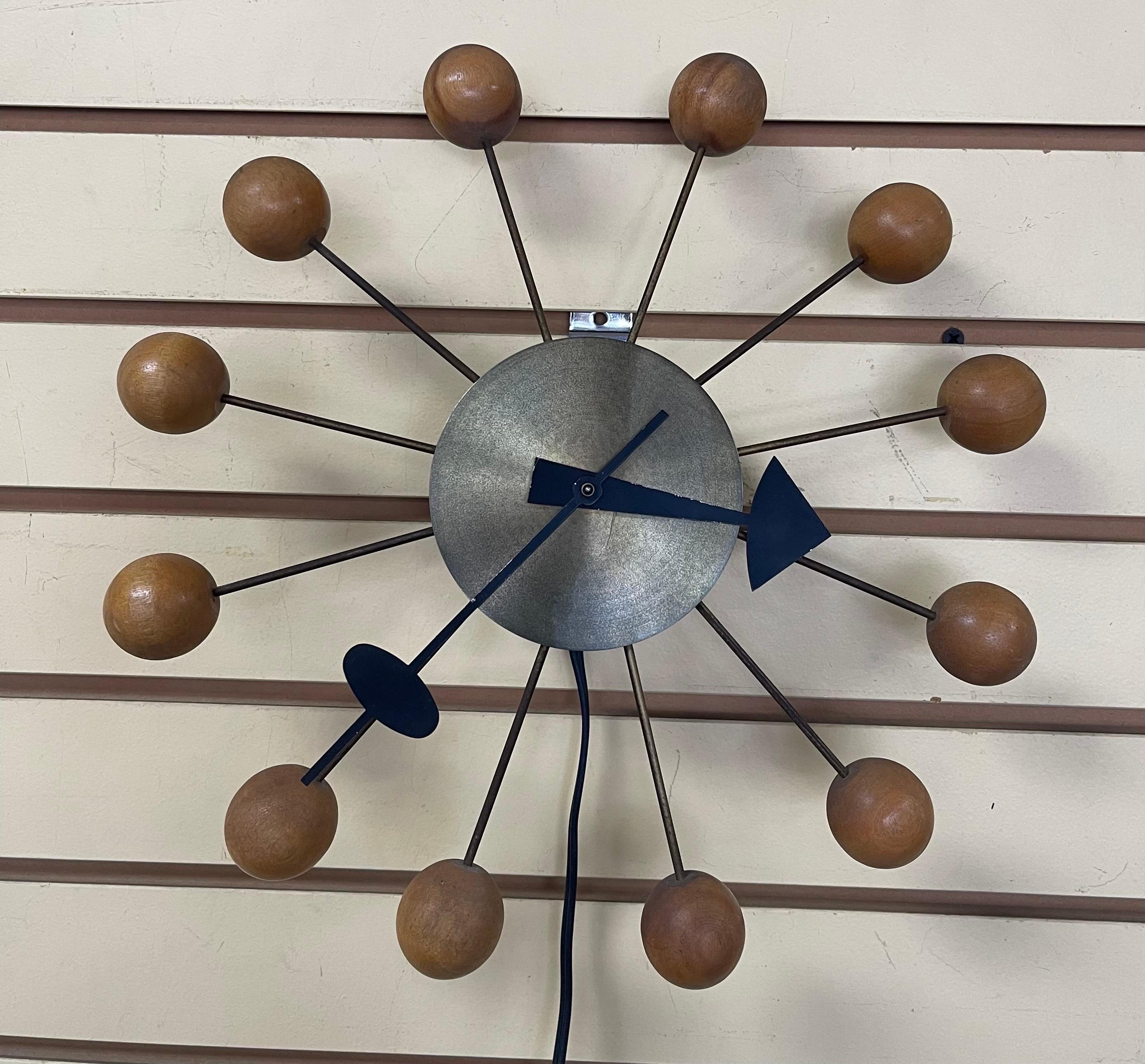 A very hard to find and early iconic ball clock designed by George Nelson for Howard Miller, circa 1950s.  The clock is in original vintage condition with an 8 feet long plug in electrical cord (the cord may have been replaced), brushed brass