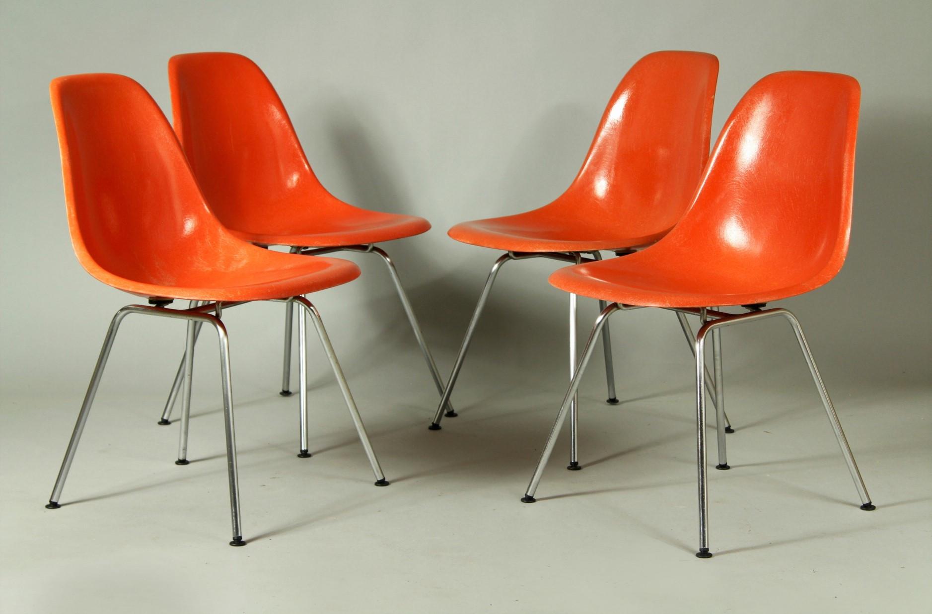 Vintage 1950s orange fiberglass dining shell chairs designed by Charles and Ray Eames for Herman Miller. Each shell is marked with Herman Miller M stamp, this stamp was used in 1958 and 1959. These chairs are in very good original