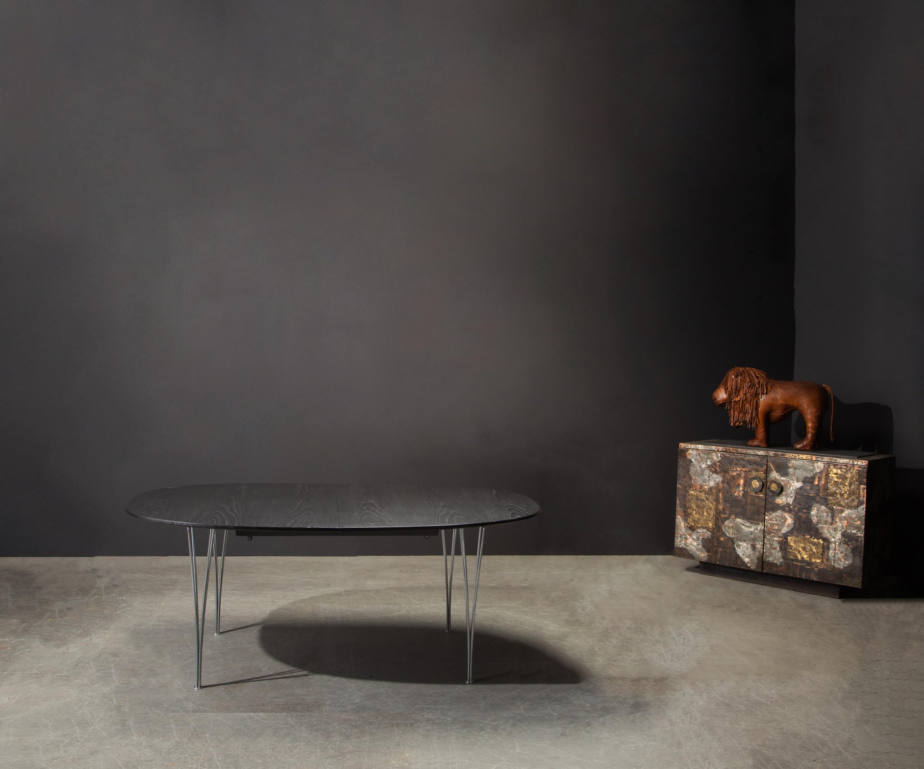 This beautifully restored table is the Super Ellipse Elliptical table by Piet Hein for Fritz Hansen, signed and dated 1973, comes with 3 leaves that transform the table to a monumental 117