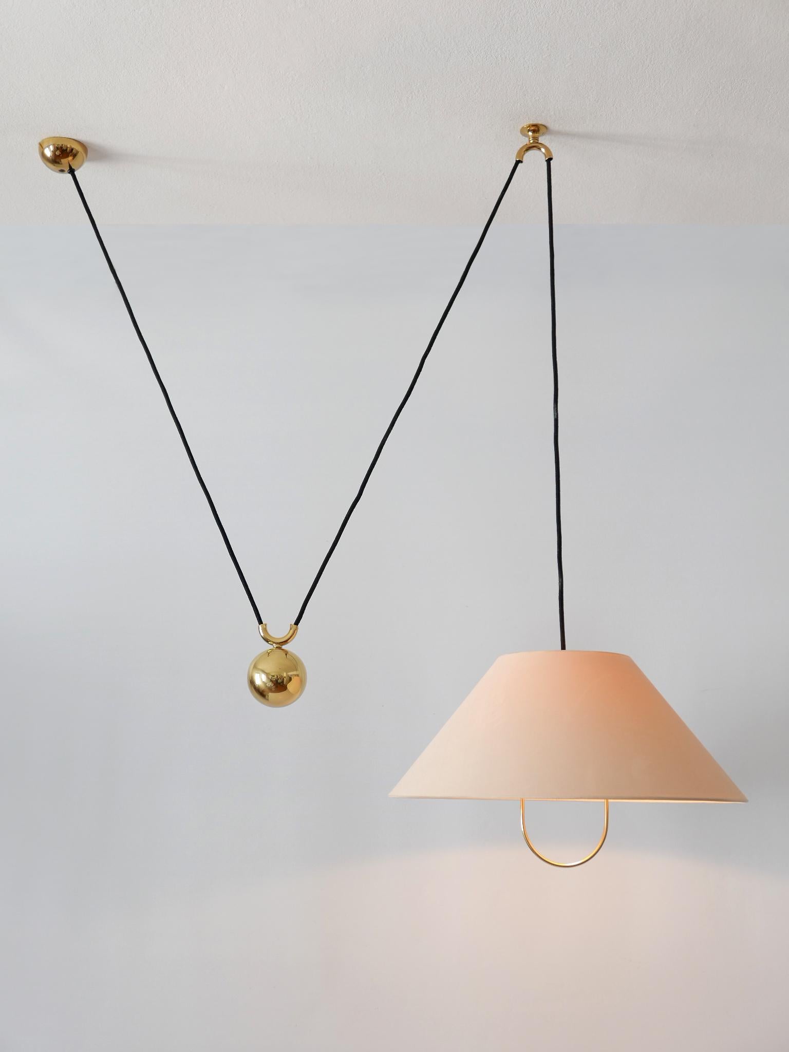 Extremely rare and early counterweight pendant lamp or hanging light. Designed and manufactured by Florian Schulz, Germany, 1960s.

Executed in brass and fabric, the lamp comes with 1 x E27 / E26 Edison screw fit bulb holder, is wired and in