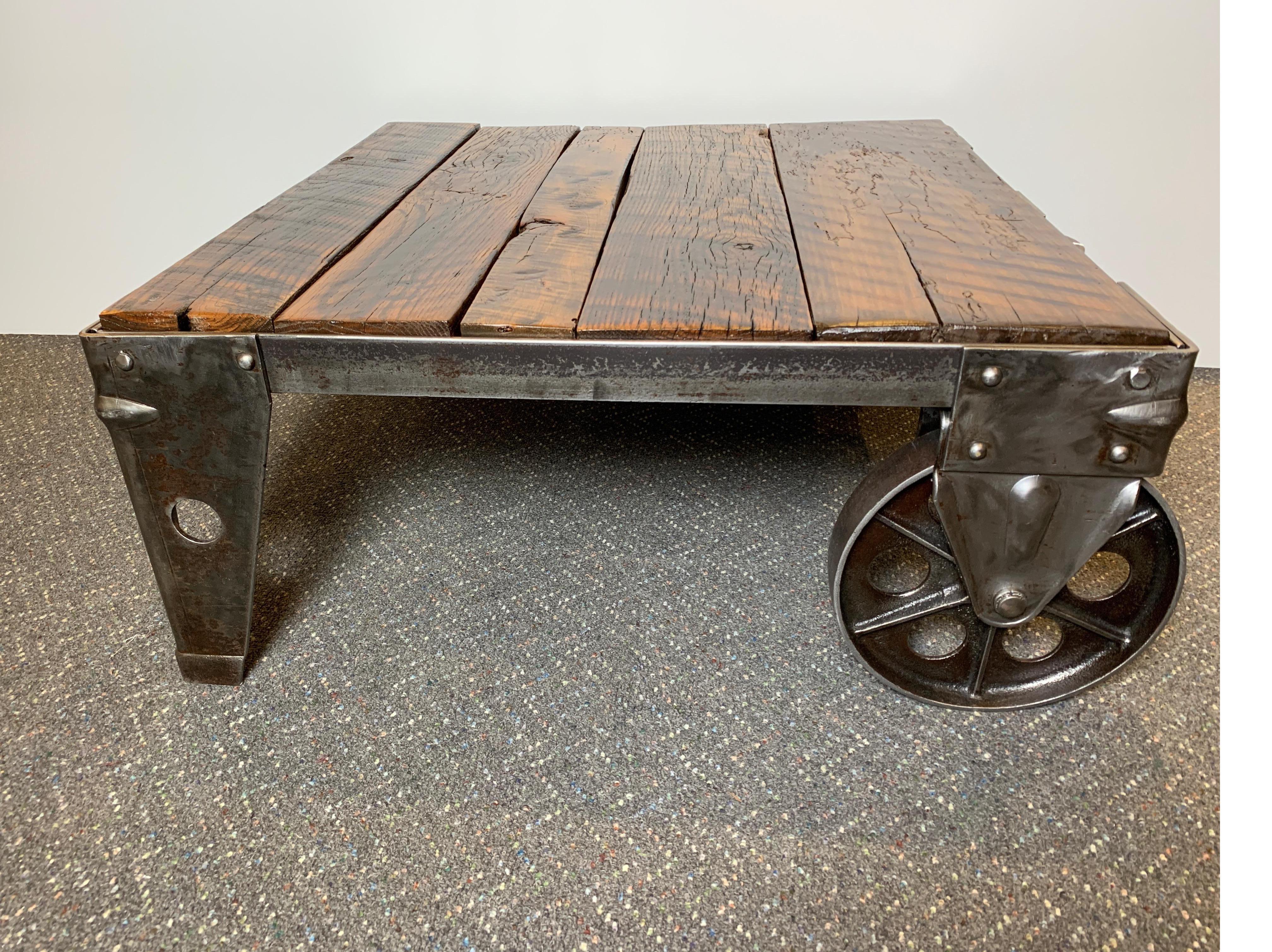 Early factory cart made of wood and steel with excellent big steel wheels has been refinished and repurposed for use as a coffee table. Striking and functional!