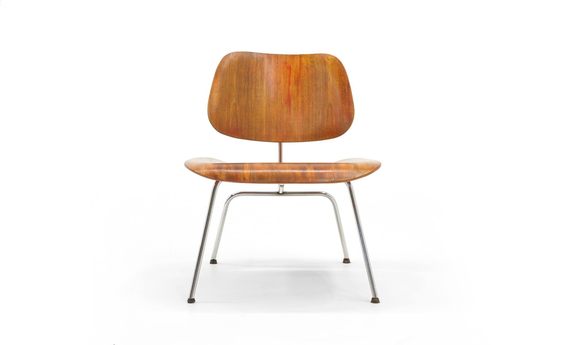 Very early Charles Eames and Ray Eames LCM, for Evans Products Company, Venice, CA, circa 1945. Red aniline-dyed molded plywood, polished chrome, original glides. Early frame construction. Signed with Evans label.
  