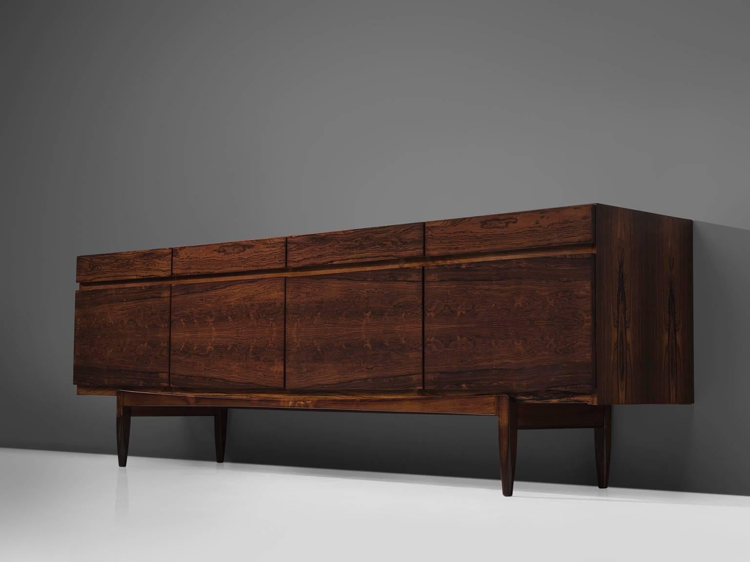 Ib Kofod-Larsen for Faarup, sideboard FA66, rosewood, Denmark, 1960s. 
 
This credenza by Kofod-Larsen shows delicate crafted details and incredible rosewood flames. The flames are bookmatched due to which a very organic yet graphic pattern is