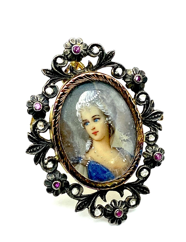 Rich colored Cameo Painted Pin with Diamonds 

Silver with gilded gold metal
Adorned and ornate bezel is encrusted with antique cut diamonds and rubies. 
The framing encompassing the cameo is a copper based metal.
The Cameo is hand painted and most