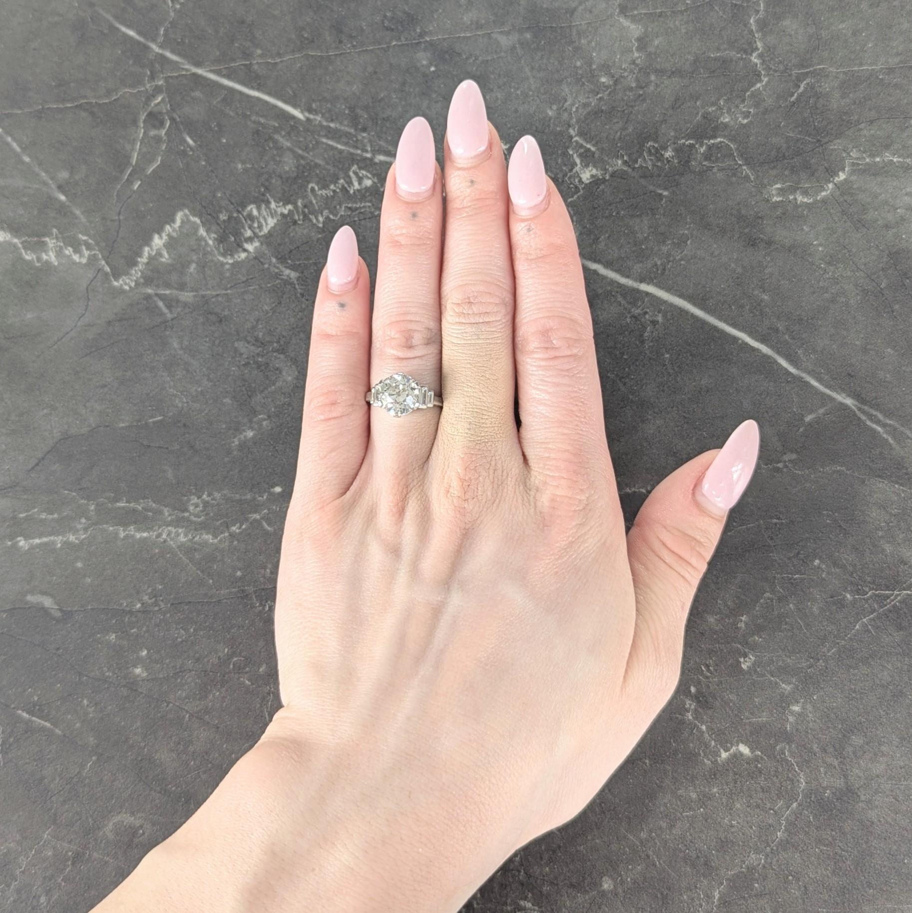 Centering an old European cut diamond weighing 3.66 carats total - J color with VS1 clarity
Set with tab like prongs and flanked by stepped cathedral shoulders bar set with diamonds
Baguette cut and weighing approximately 0.26 carat total - eye