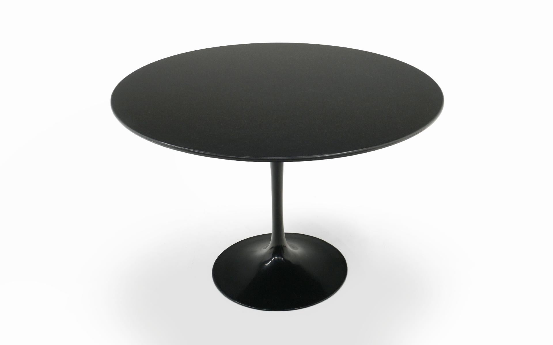 Early production 42 inch round pedestal dining table designed by Eero Saarinen and manufactured by Knoll International. Heavy, thick black granite top and lacquered cast iron base. This is not cast aluminum as used in later production. Retains early