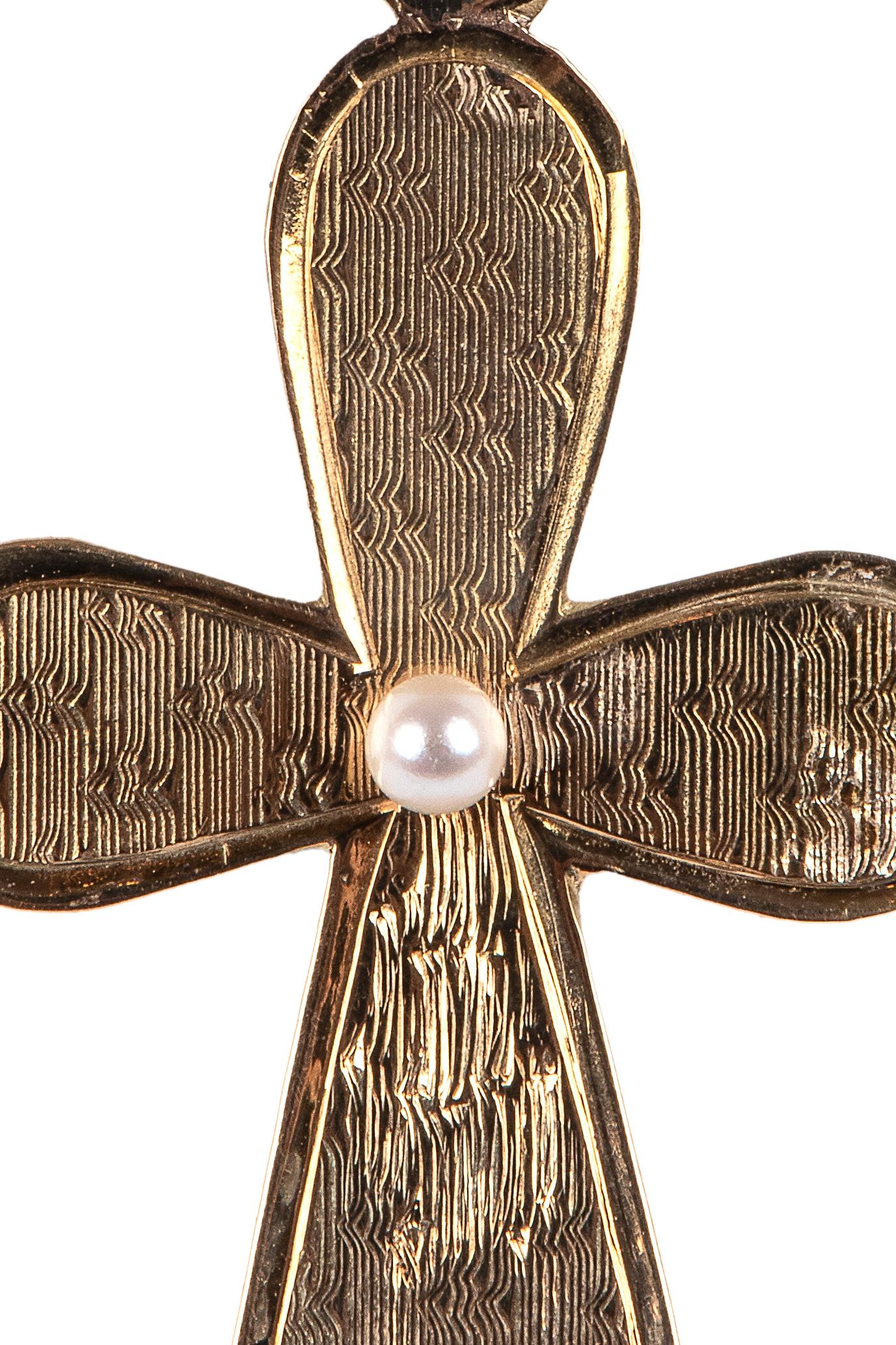 A rare Russian gold cross from the Romanov era, period of Tsar Alexander II, in 14k gold, the front decorated with a guilloché or engine turned pattern centring a pearl, the reverse of polished gold. 

Moscow, 1868, hallmarked, chain not