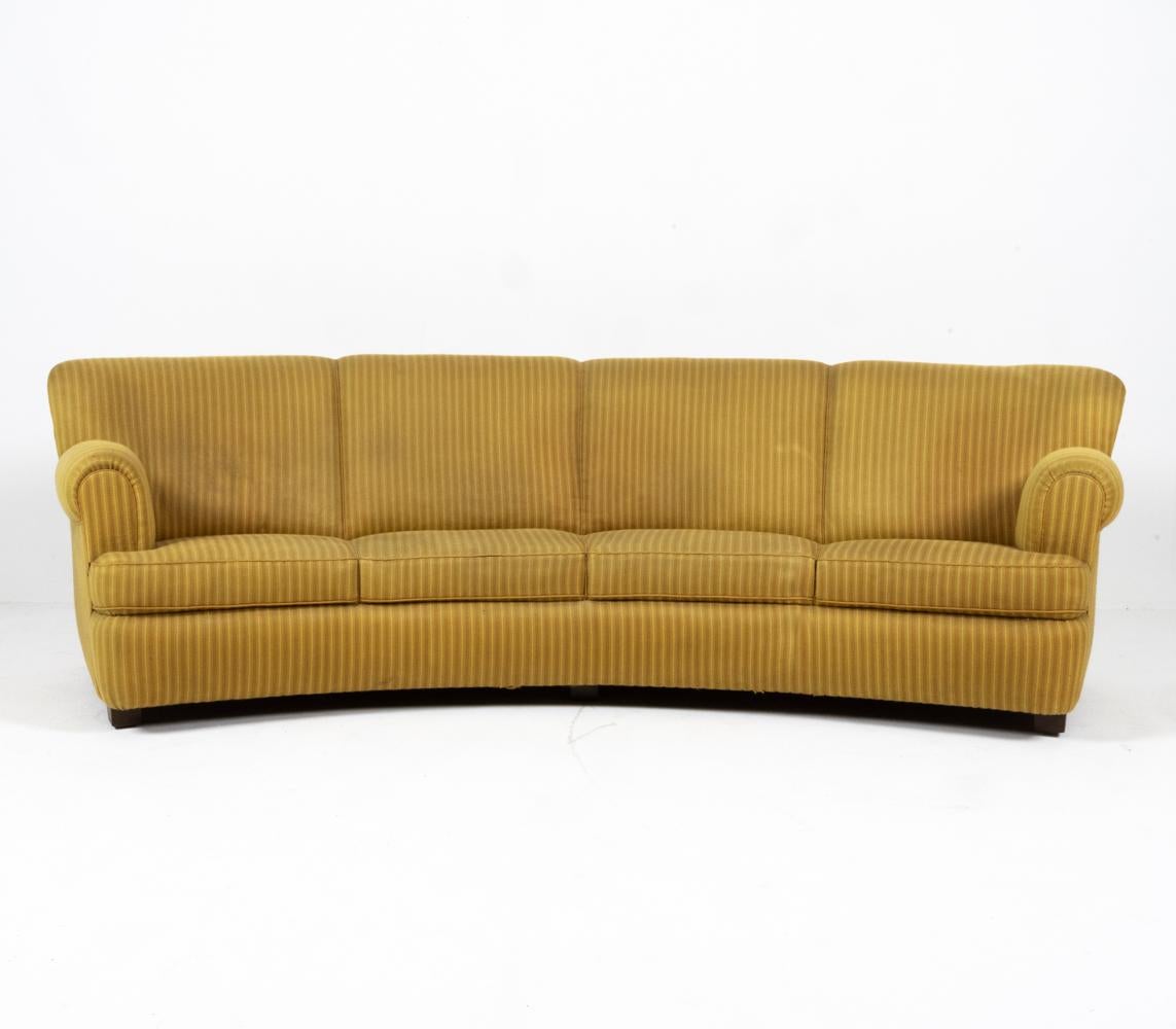 This fabulous banana-style sofa dates from the transitional period between the Art Deco and Modern design movements. It is especially rare due to its large size; it can easily seat four guests, or a family of two (plus dogs!) making it the perfect