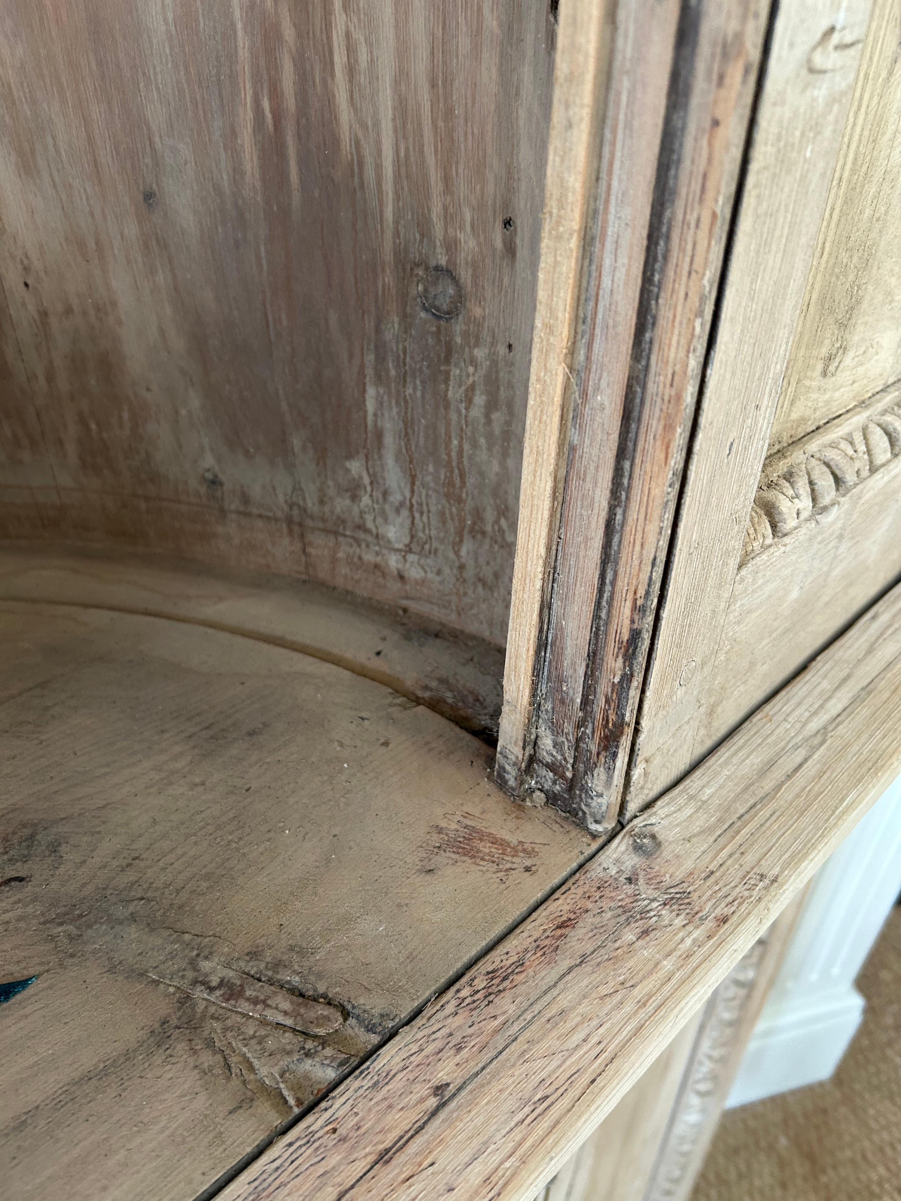 Increíble armario esquinero antiguo de pino blanqueado y natural, con una magnífica gruta interior abovedada para exposición en la mitad superior y dos puertas paneladas debajo con almacenaje en el interior.  Bonitas molduras en la parte superior y