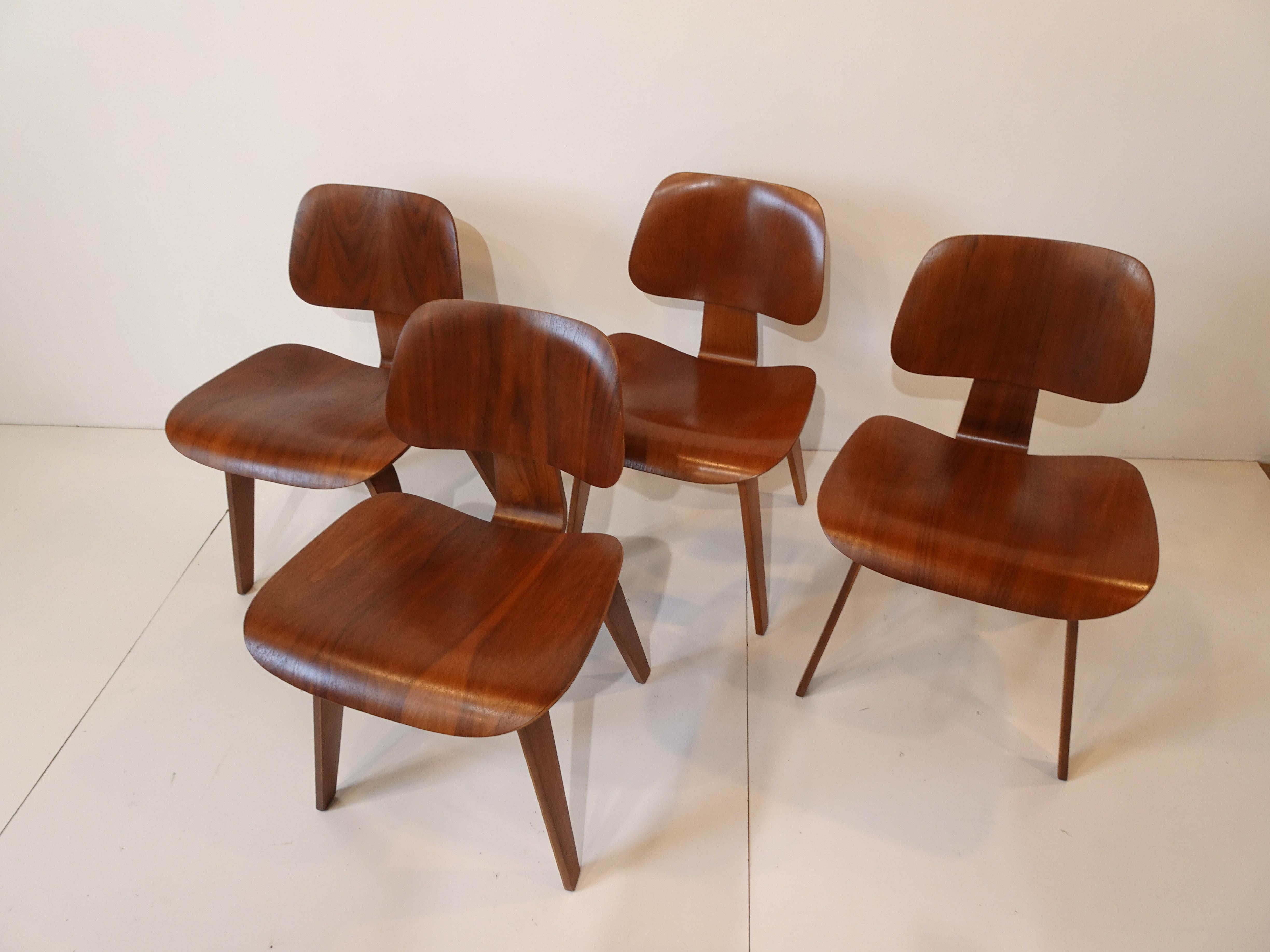 A set of four early sculptural walnut DCW (dining chairs wood) having beautiful compound curves designed by the husband and wife team of Ray and Charles Eames. Winning first place in the 'organic Design in Home furnishings' competition in the 1940's