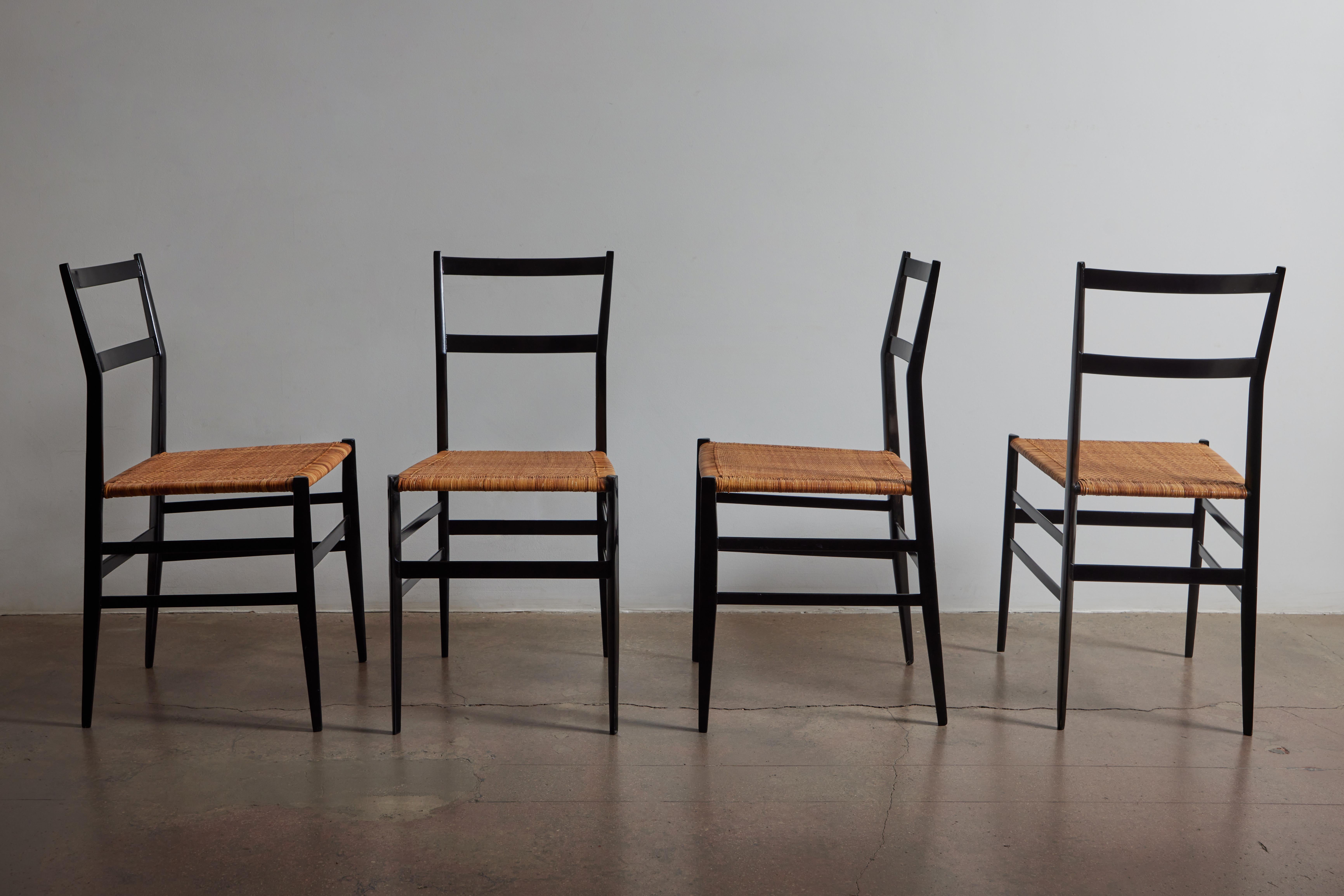 Ensemble historique de quatre chaises Superleggera de Gio Ponti avec cannage d'origine et structure en bois laqué noir. Fabriqué en Italie vers 1957.
