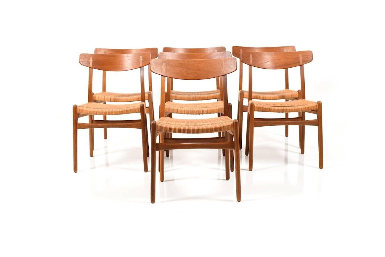 Early set of seven (7) dining chairs in oak and teak by Hans J. Wegner. Seats in original braid rattan. Model CH23. Produced by Carl Hansen.
Note: The CH23 is an early example of the unique design language and craftsmanship of Hans J. Wegner. It