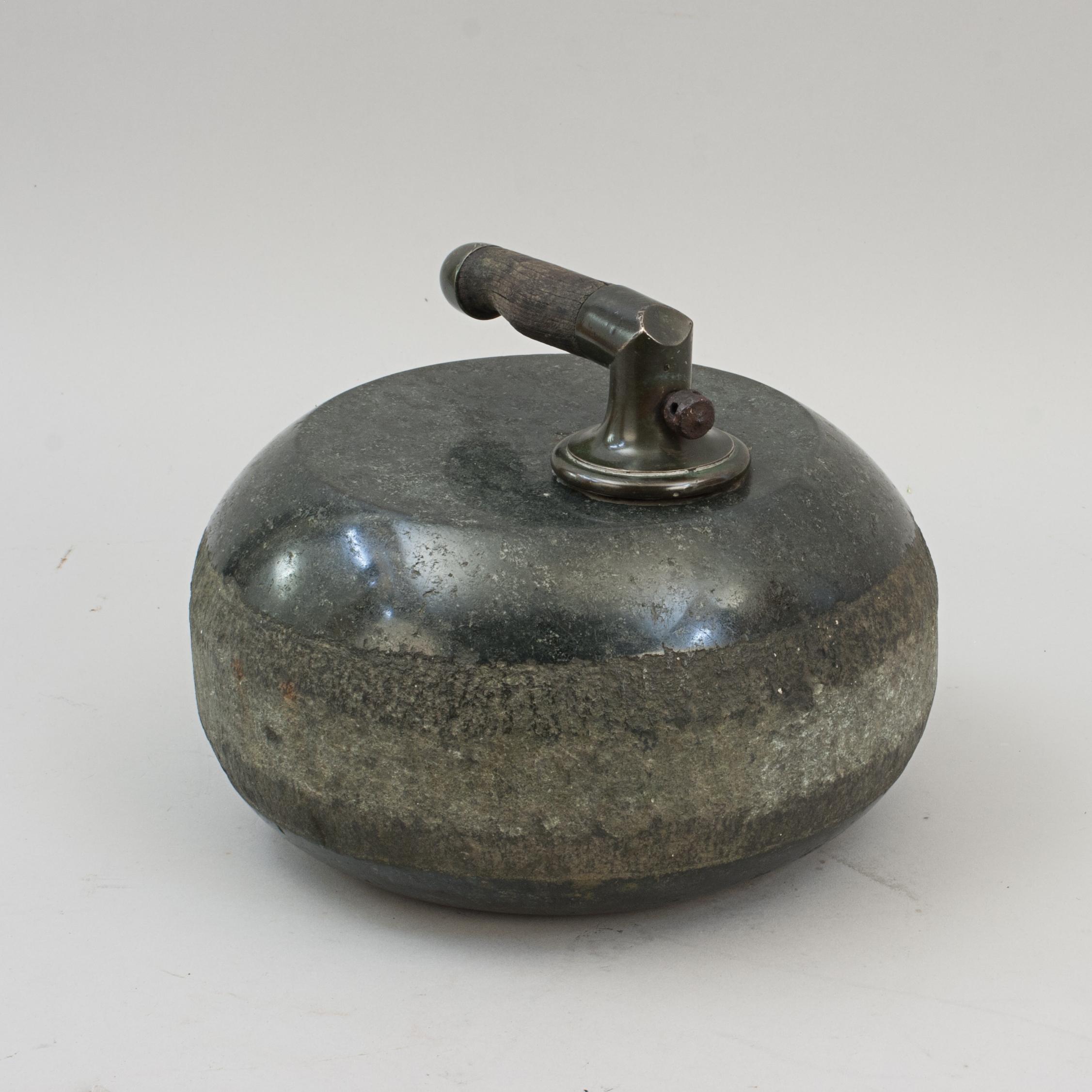 Antique Granite Curling Stone.
A late 19th century single-soled curling stone with a brass (gun metal) and wood handle. The handle is fixed to a bar that is set into the top of the stone.

The stone is 25 cm in diameter and 14 cm high with out the