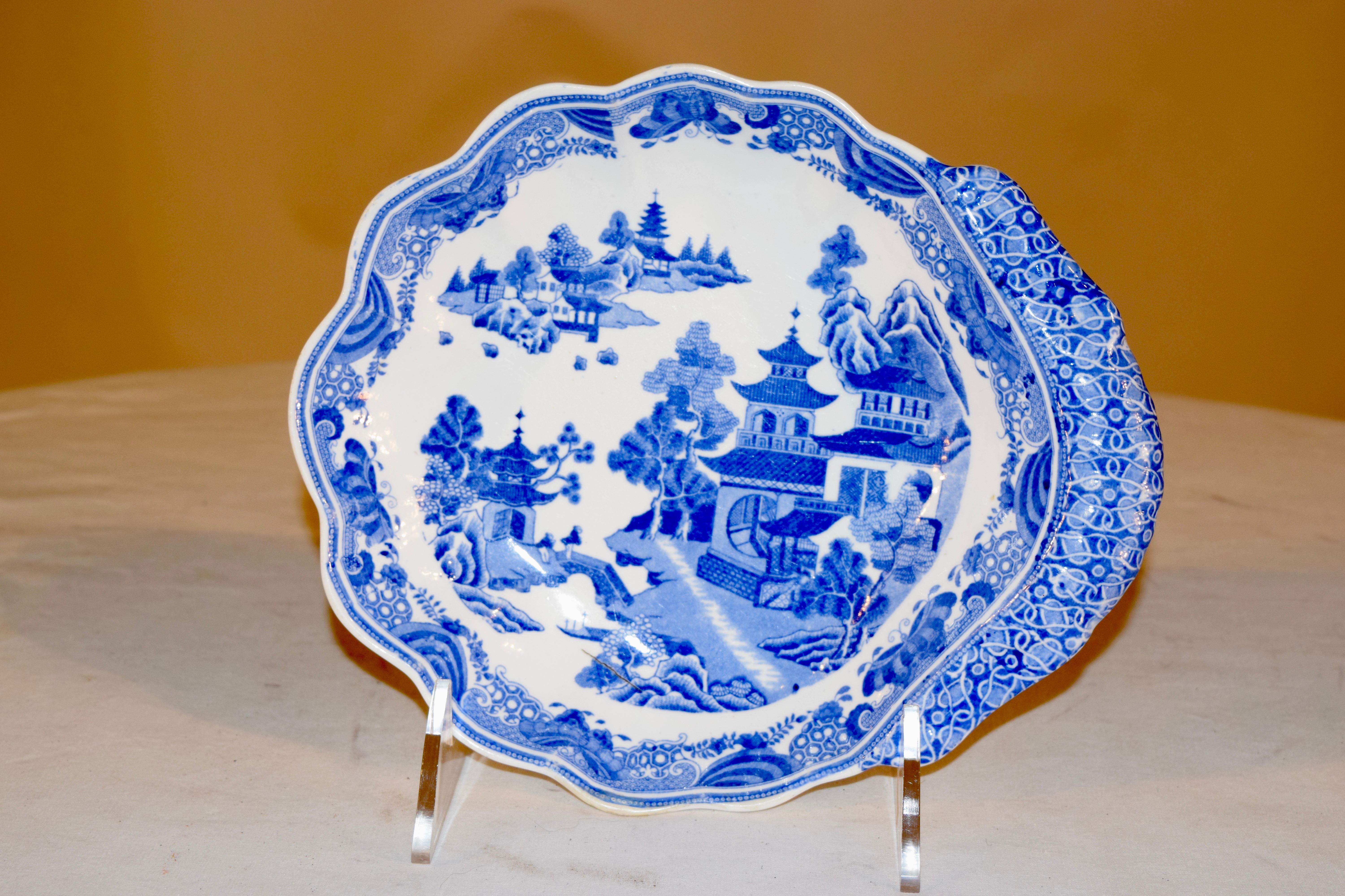 Piatto da portata firmato Spode dei primi del XIX secolo con manico sagomato e bordo smerlato. Il disegno raffigura un grazioso villaggio asiatico.
