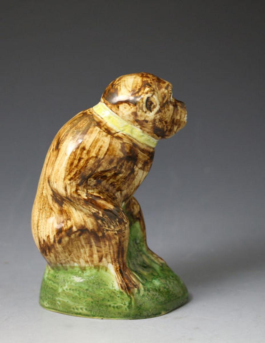 Dated: c. 1780 Staffordshire England

A very rare Wood family pottery figure of a pet monkey with a yellow collar and lead seated on a hollow green base. The coloured glaze is typical Wood type and the figure dates to the late 18th century period,