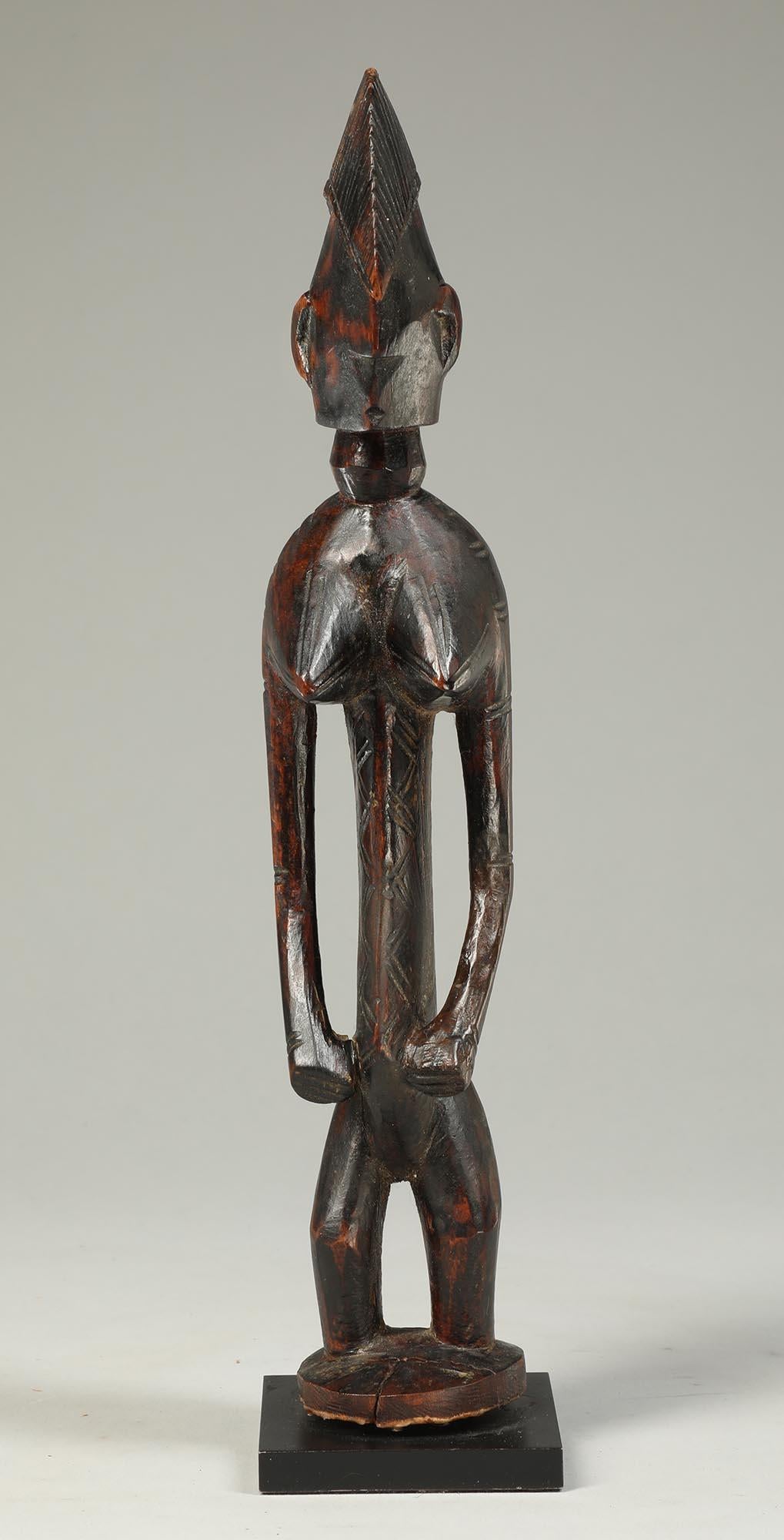 Early Bambara or Malinke standing female figure with arms at sides, heavy wear and polish from handling and use.  Possibly cut from the top of prestige staff.  Fine refined abstract face.
From an old European collection.
10 1/2 inches high, on