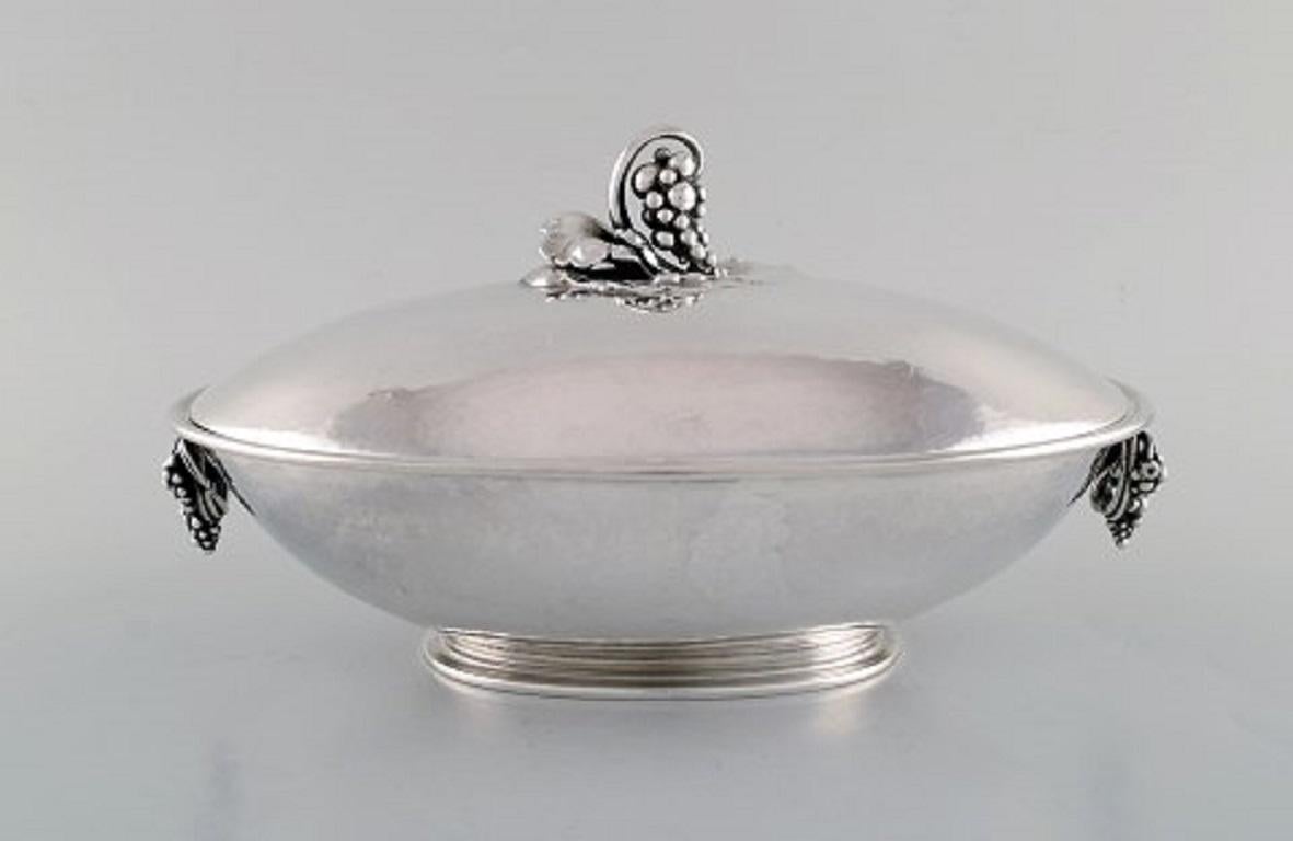 Early sterling silver Georg Jensen large oval tureen with grape and floral details.
Design #408B by Georg Jensen from circa 1921.
Measures: 26.5 x 18 x 14 cm.
In very good condition.
Stamped. With French import stamps.
Weighs 54 oz (1530 grams).