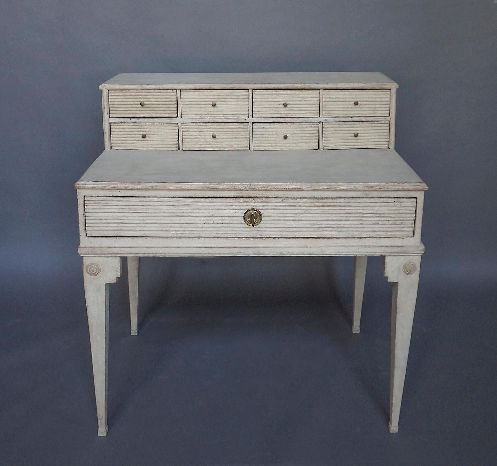 Period Swedish writing desk, circa 1820, with early hutch fitted with 8 small drawers. Full-width drawer below the writing surface, and shaped legs with applied roundels in the slightly later base.