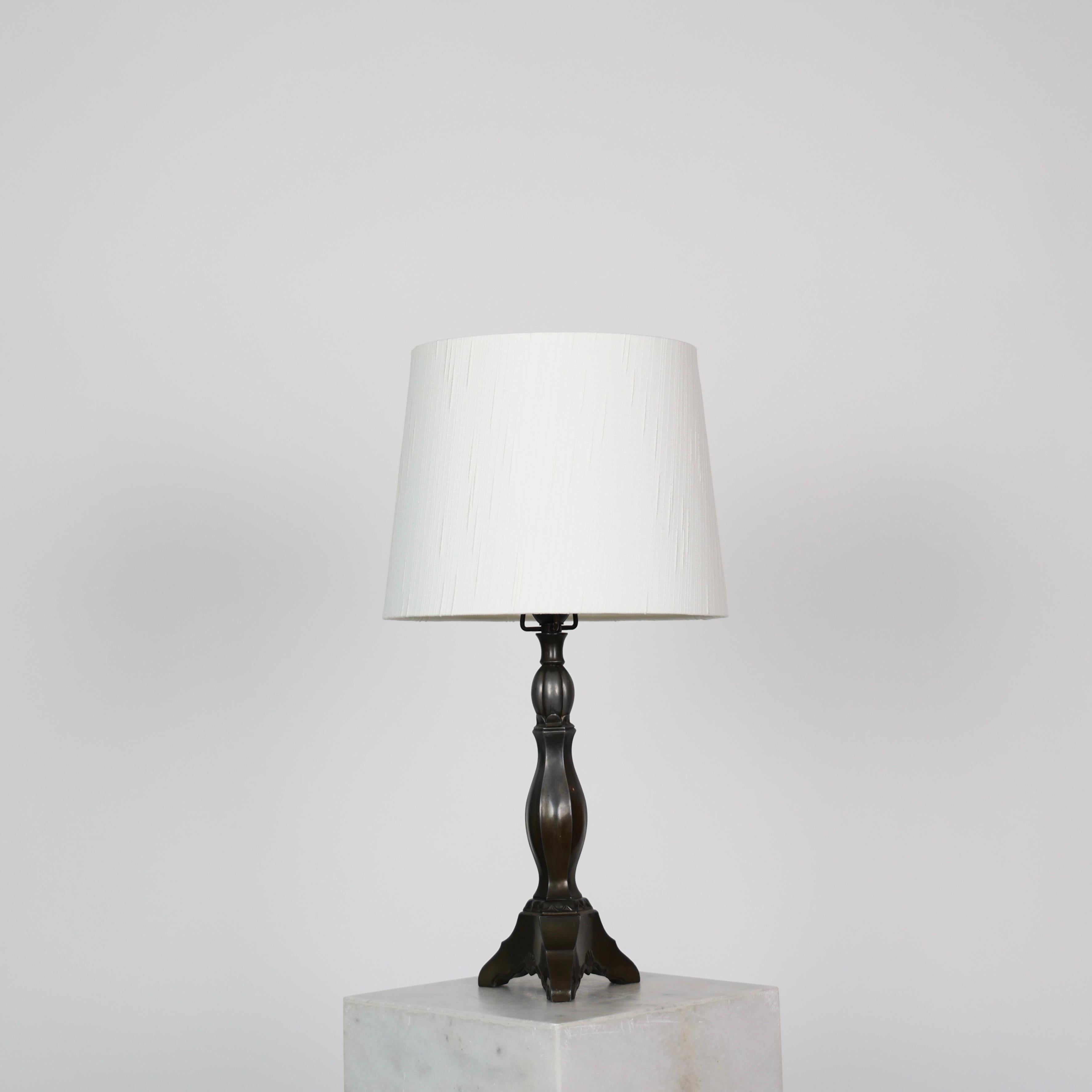 Lampe de table Diskometal réalisée par Just Andersen dans les années 1920.

* Lampe de table Diskometal avec base tripode, col fin et abat-jour blanc.
* Designer : Just Andersen
* Style : D01
* Année : 1926
* Condition : Etat vintage moyen. Gravure