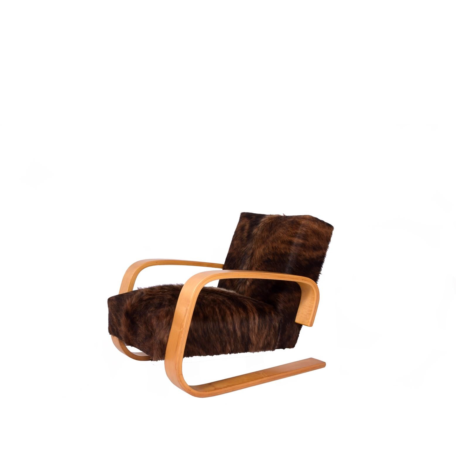 Early tank chair with birch arms and spring construction seat and back. Reupholstered in cowhide. Made by Artek in Sweden. This chair was produced between 1940 and 1955.