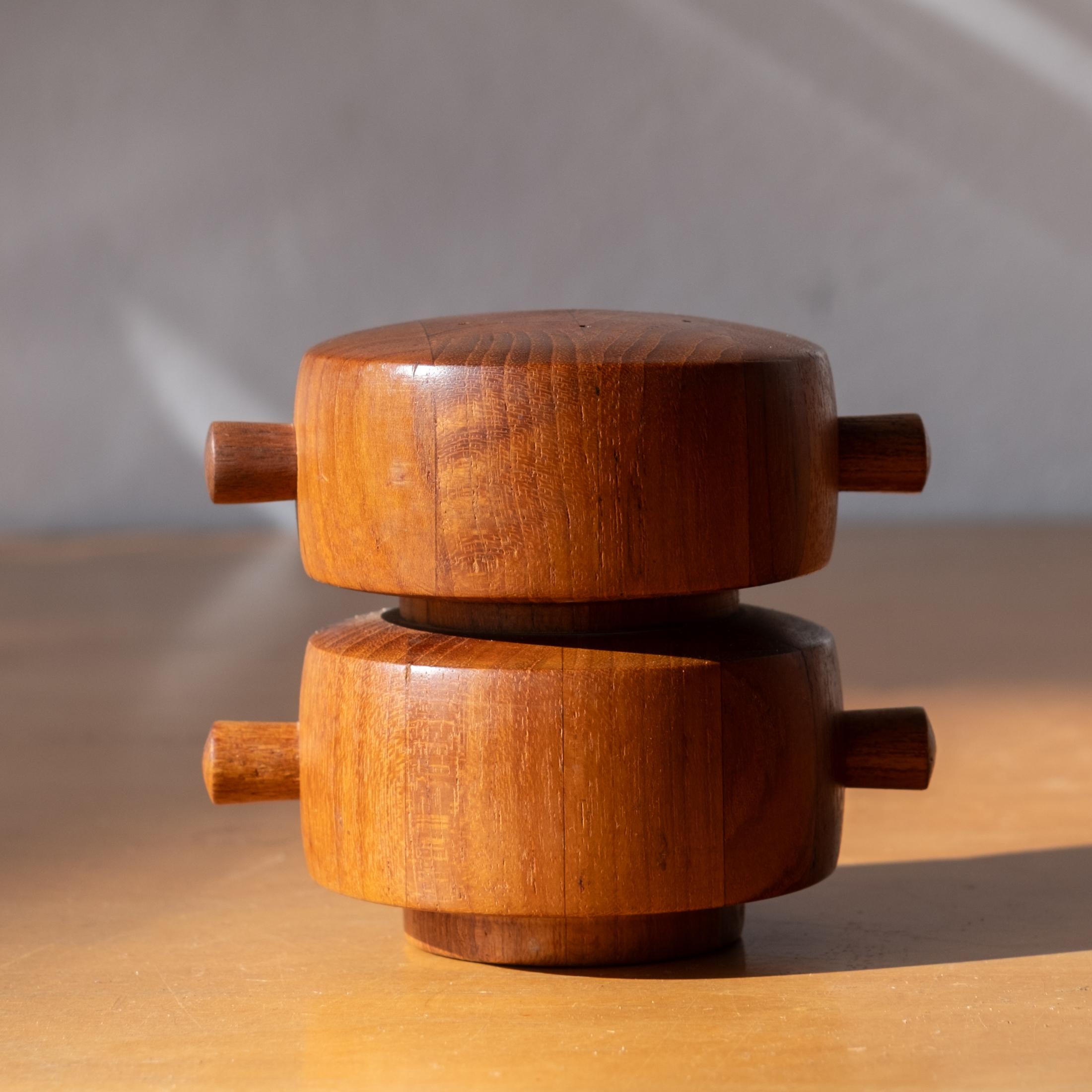 Early teak combination salt shaker and pepper mill by Jens Quistgaard. Metal grinding mechanisms produced by Peugeot Freres. The mill was produced by Dansk in Denmark. The top is for salt and the bottom section produces pepper. The fill pegs for
