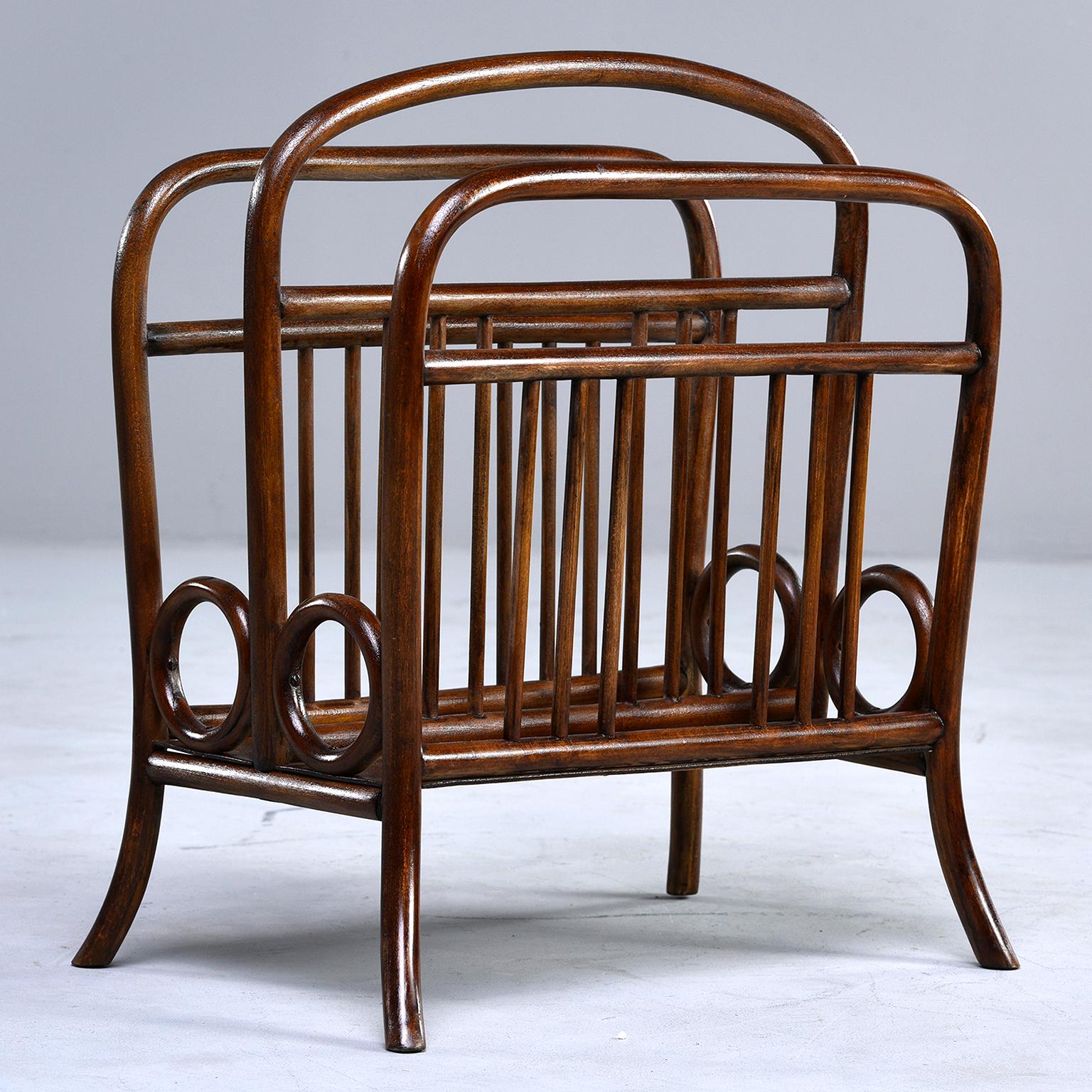 Thonet circa 1920 bentwood magazine rack features its original dark stained bent beechwood in a Classic design with partial original Thonet paper label affixed.
  