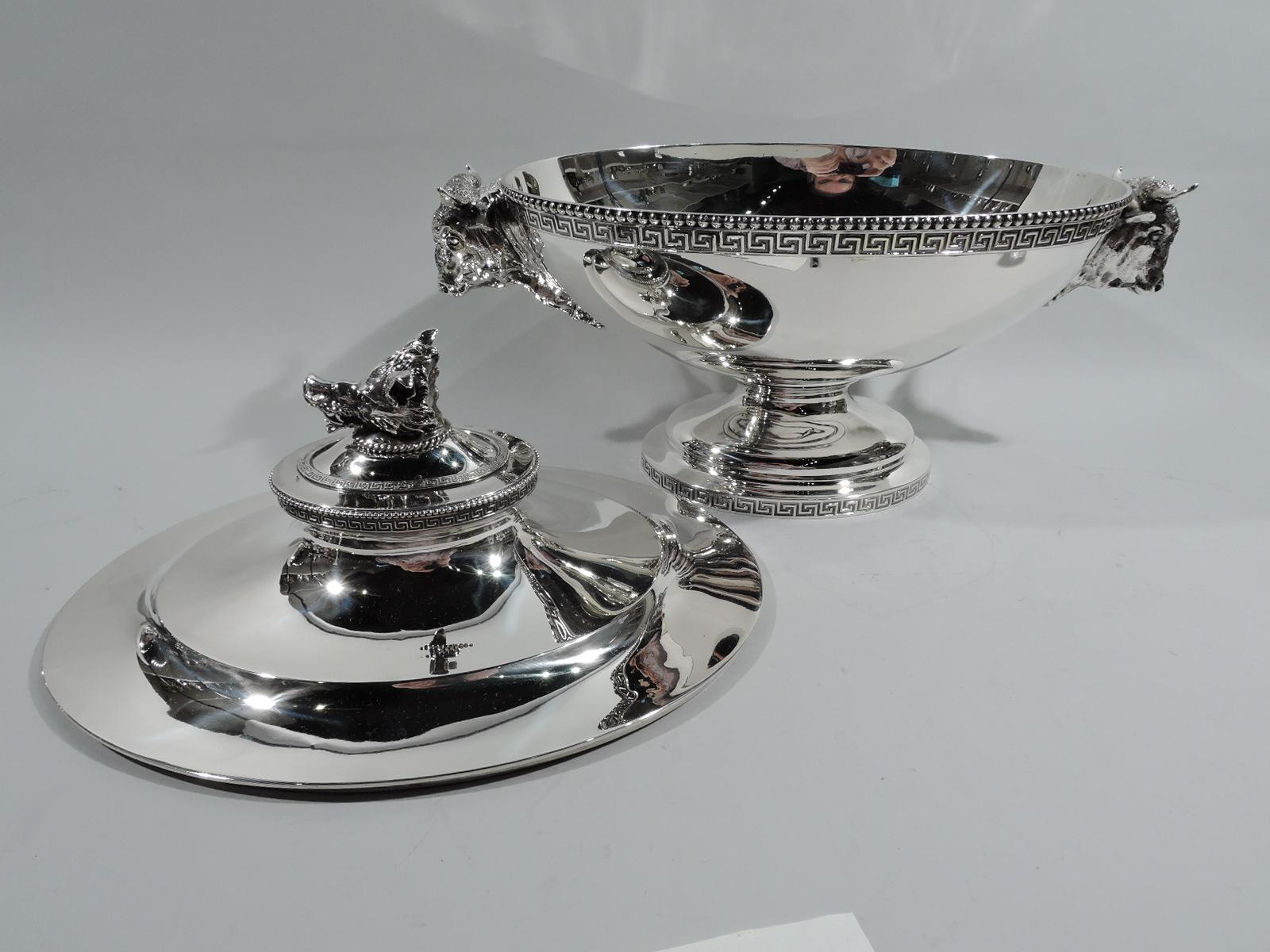 Early sterling silver soup tureen. Made by John C. Moore for Tiffany & Co. at 550 Broadway, New York. Ovoid bowl on domed foot; cover domed. Beaded and fretwork borders. Cast animal heads: Bowl ends have shaggy, horned oxen, and cover finial is a