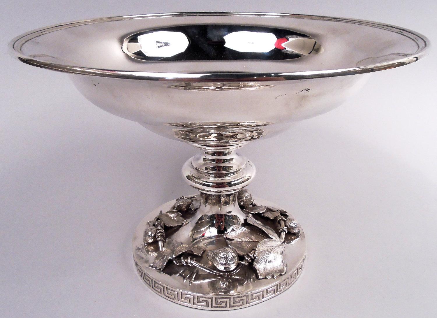 Compota clásica de plata de ley. Fabricada por Moore para Tiffany & Co. en el 550 de Broadway, Nueva York, hacia 1865. Cuenco ancho y curvo sobre astil abombado; pie redondo y elevado con borde de llave griega. Rama de fresa de fructificación