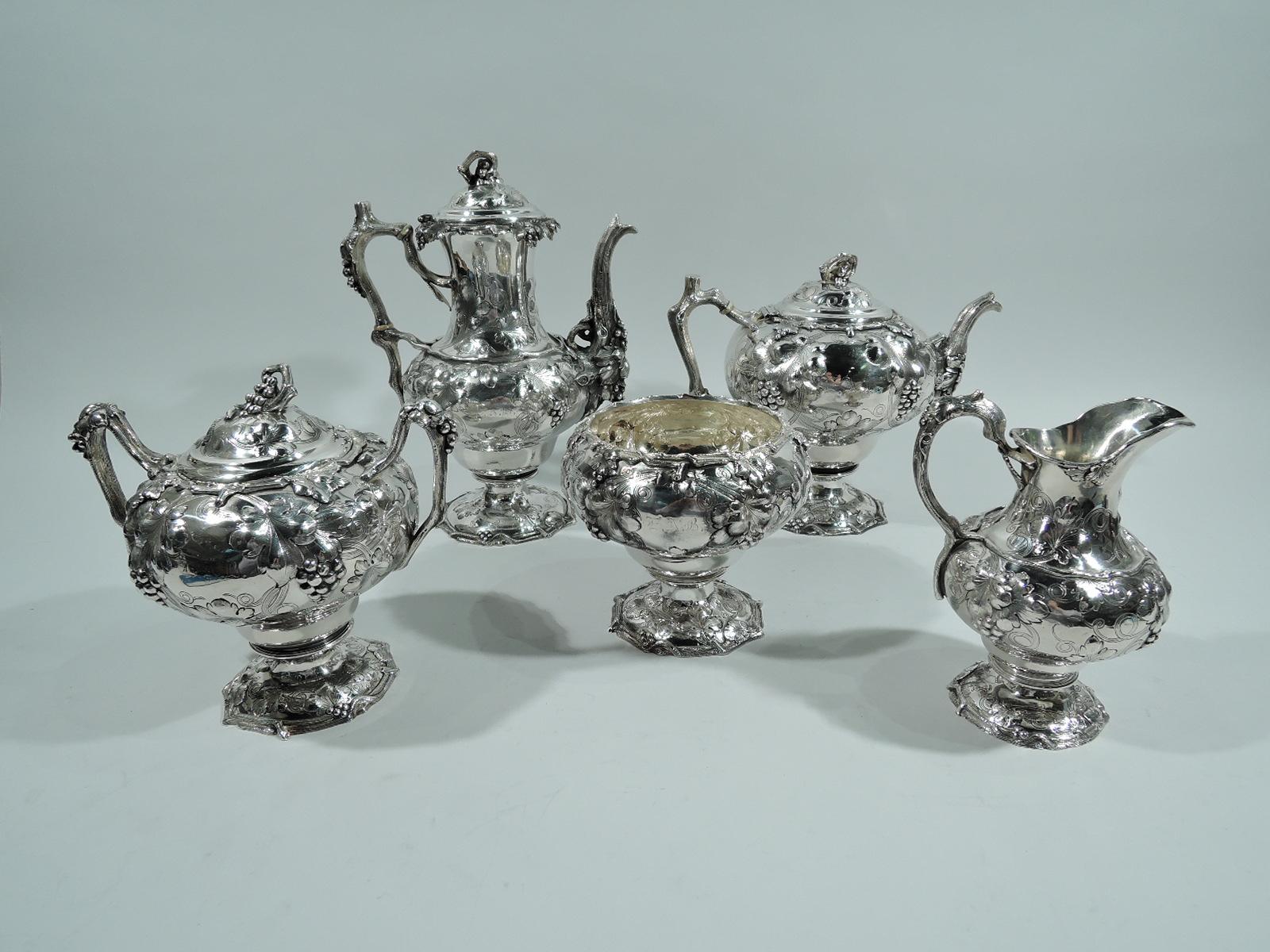Early sterling silver coffee and tea set. Made by John C. Moore for Tiffany & Co. in New York in 1850s. This set comprises 5 pieces: coffeepot, teapot, creamer, sugar, and waste bowl. Chased and engraved grape bunches and leaves as well as vine