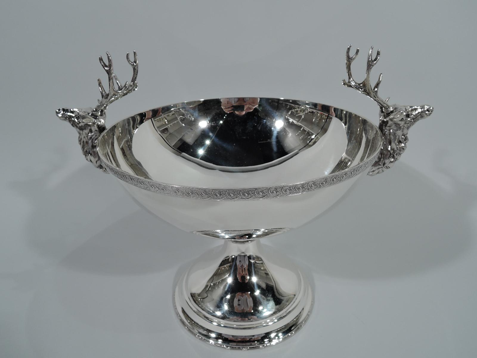 Early sterling silver compote with hunt theme. Made by Tiffany & Co. in New York. Curved bowl and domed foot. Bowl has floral rinceaux rim. Foot has reeded rim. Cast side handles in form of deer’s heads – majestic bucks with rugged coats and massive