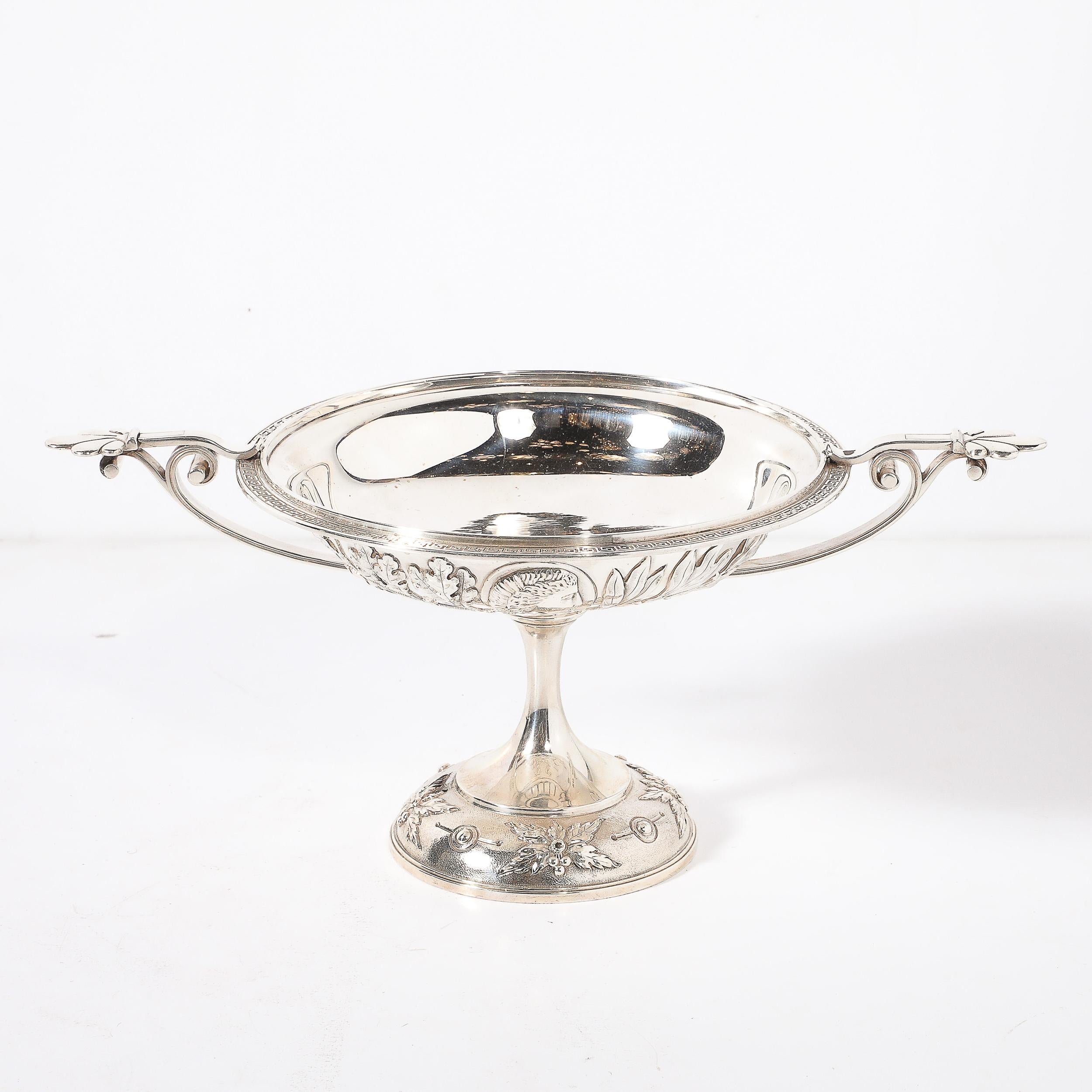 Questa magnifica ciotola con piede in argento sterling in stile Greek Revival, realizzata dai rinomati argentieri Grosjean & Woodward per Tiffany & Co., incarna la grandezza dell'artigianato americano del XIX secolo. Creato nella storica sede di