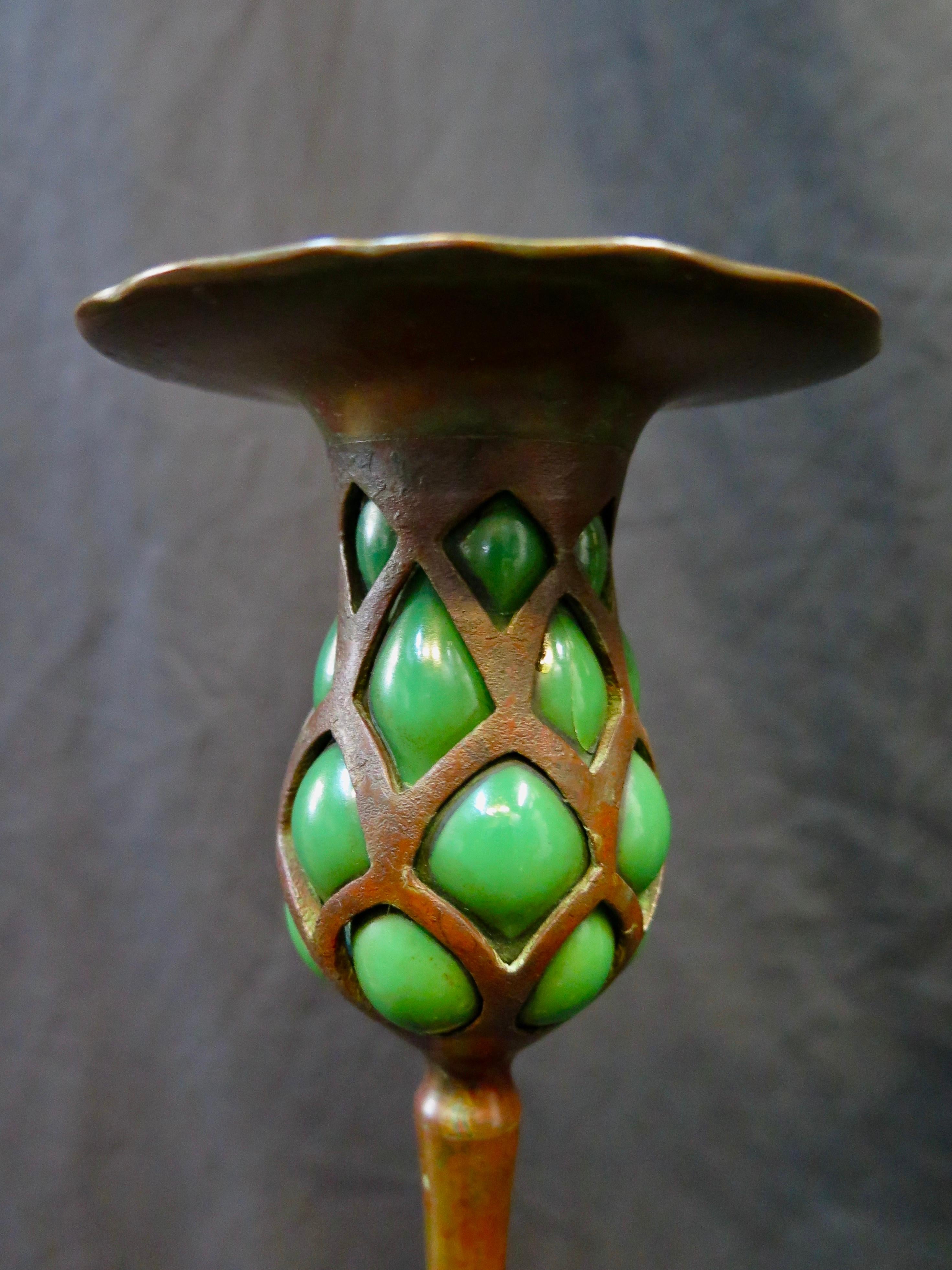 This tall & elegant patinated bronze early Tiffany Studios candlestick dates from circa 1900. It is a wonderfully preserved vintage decorative candlestick with a wide built in bobéches beautifully accenting the elongated green glass blown out bronze