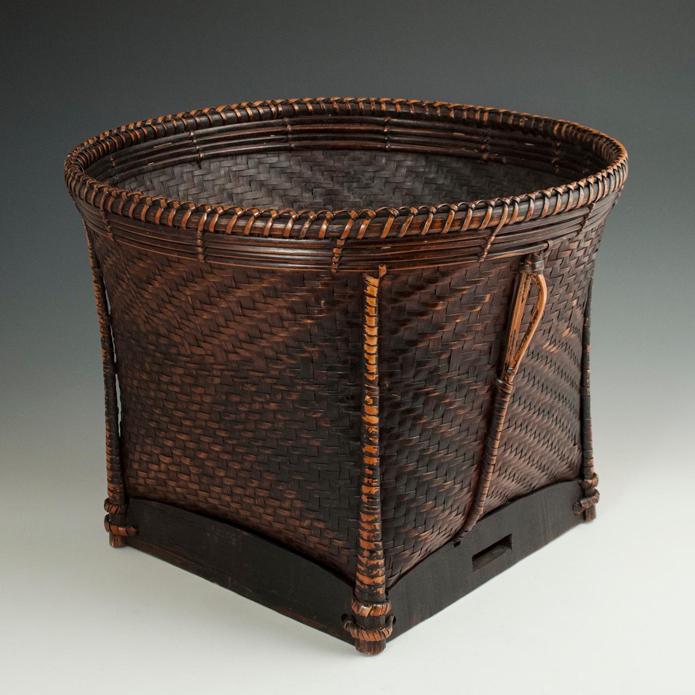 Early to Mid-20th century Bamboo Collecting Basket, Khmu People, Vietnam or Laos

A sturdy, tightly woven carrying basket from the Khmu people of Vietnam. There are two loops for the shoulder straps on the side ribs of bamboo and a wood base with