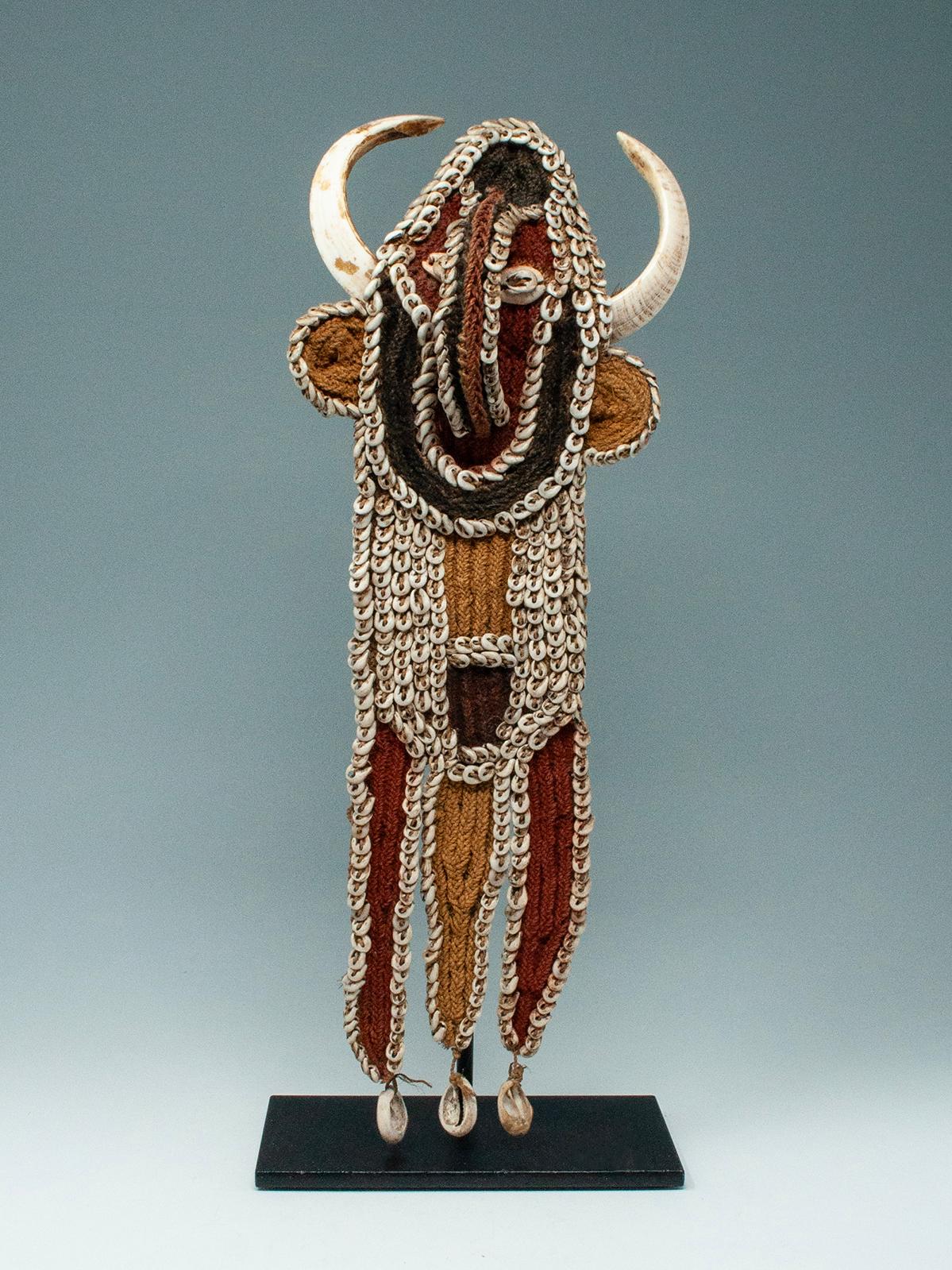 Karaut pectoral, Southern Abelam people, Papua New Guinea
Fiber, boar's tusks, nassa and cowrie shells, pigment
15 by 5.25 inches (38 by 13.3 cm)

This finely woven karaut boar’s tusk pectoral is from the Southern Abelam of Papua New Guinea. The