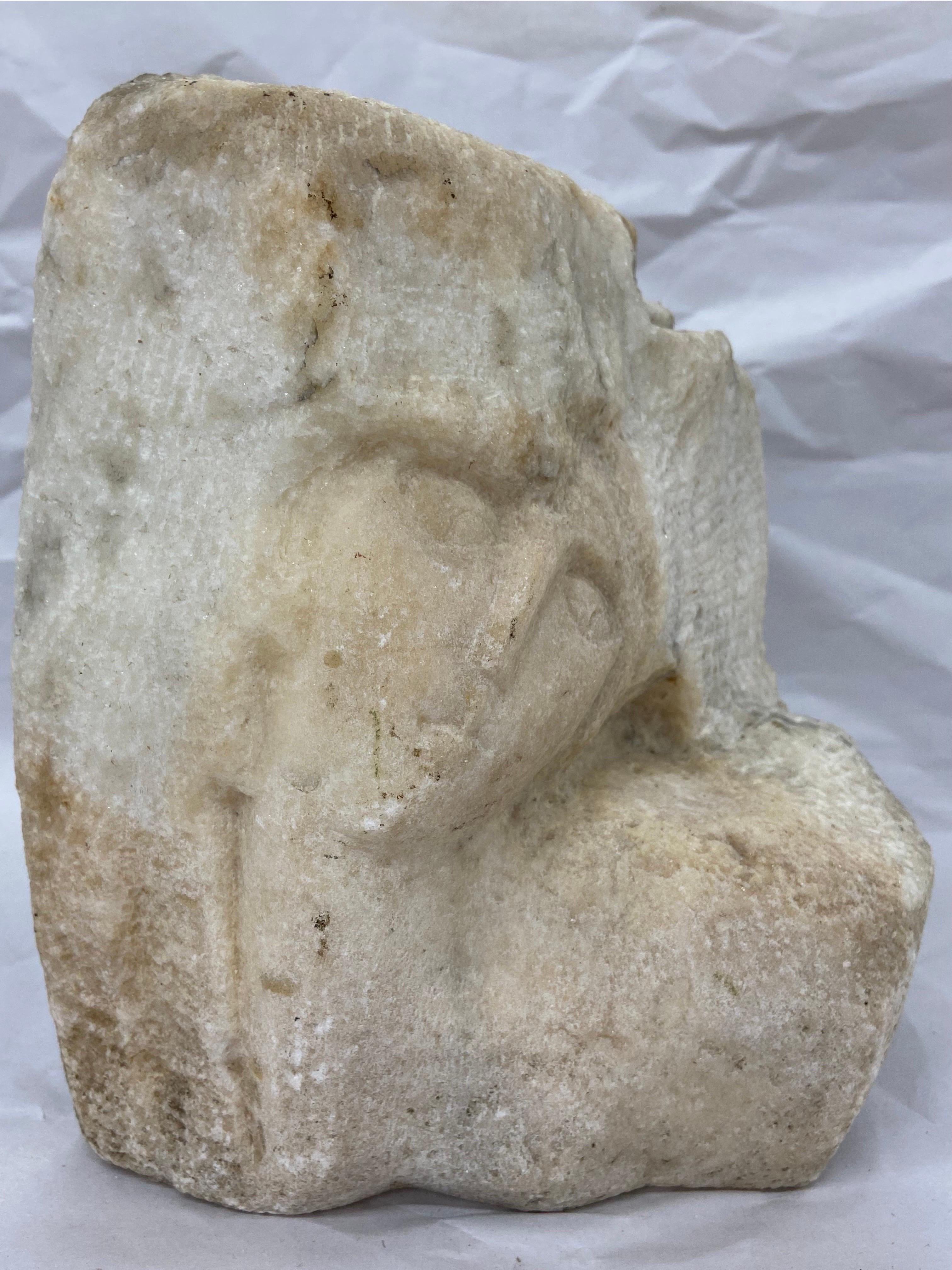 An early to mid 20th century carving of a woman's face, neck and decollete carved in stone. This sculpture is reminiscent of the modernist masterworks of the 1930's from both Europe and America. The face is shown from the front with the sitter's