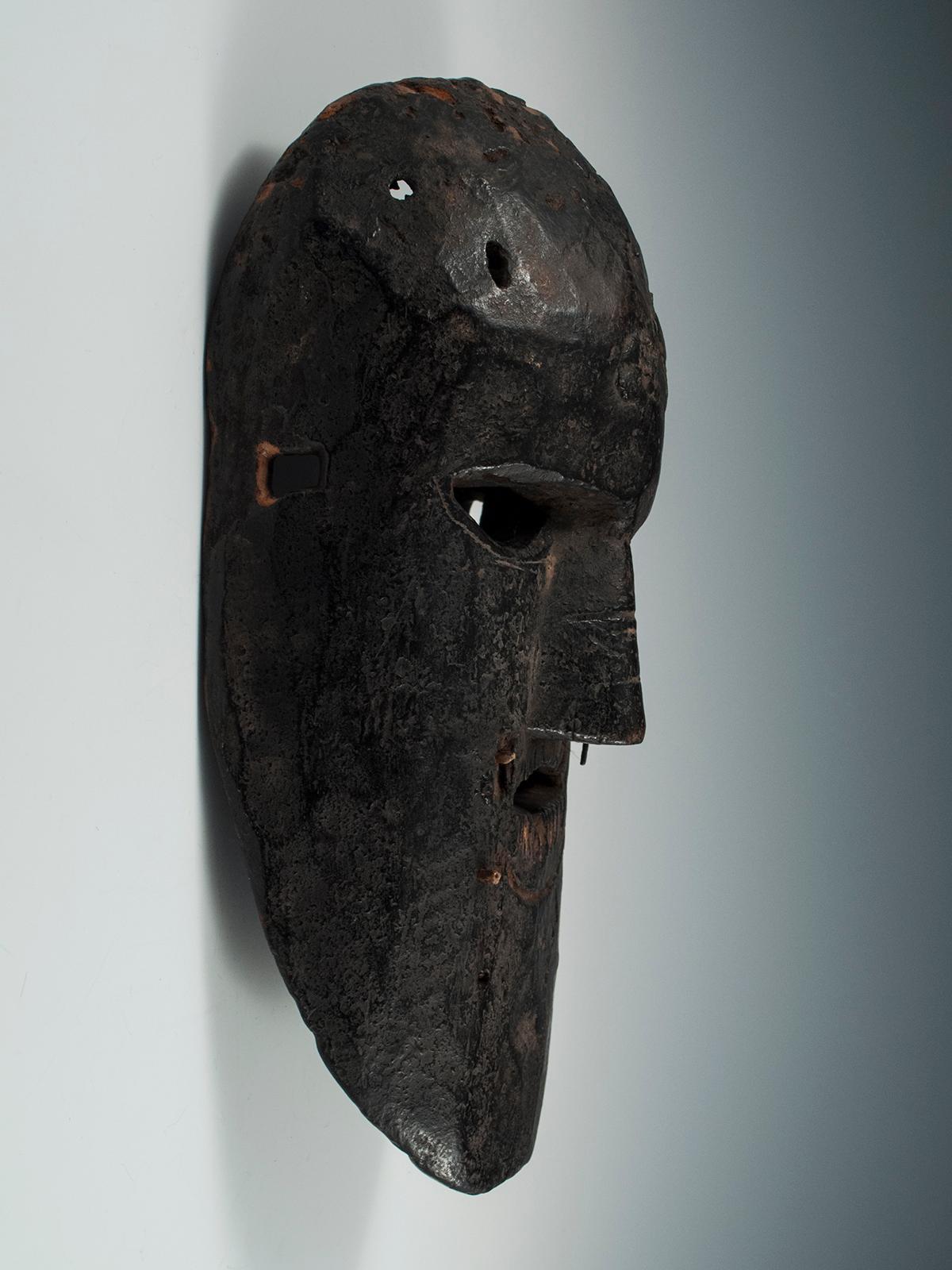 Early to mid-20th century Tribal mask, Middle Hills, Nepal
A stern brow and a multitude of teeth give this pared down Middle Hills mask a powerful presence. The yak hair that would have created beard and mustache is long gone, but the magical