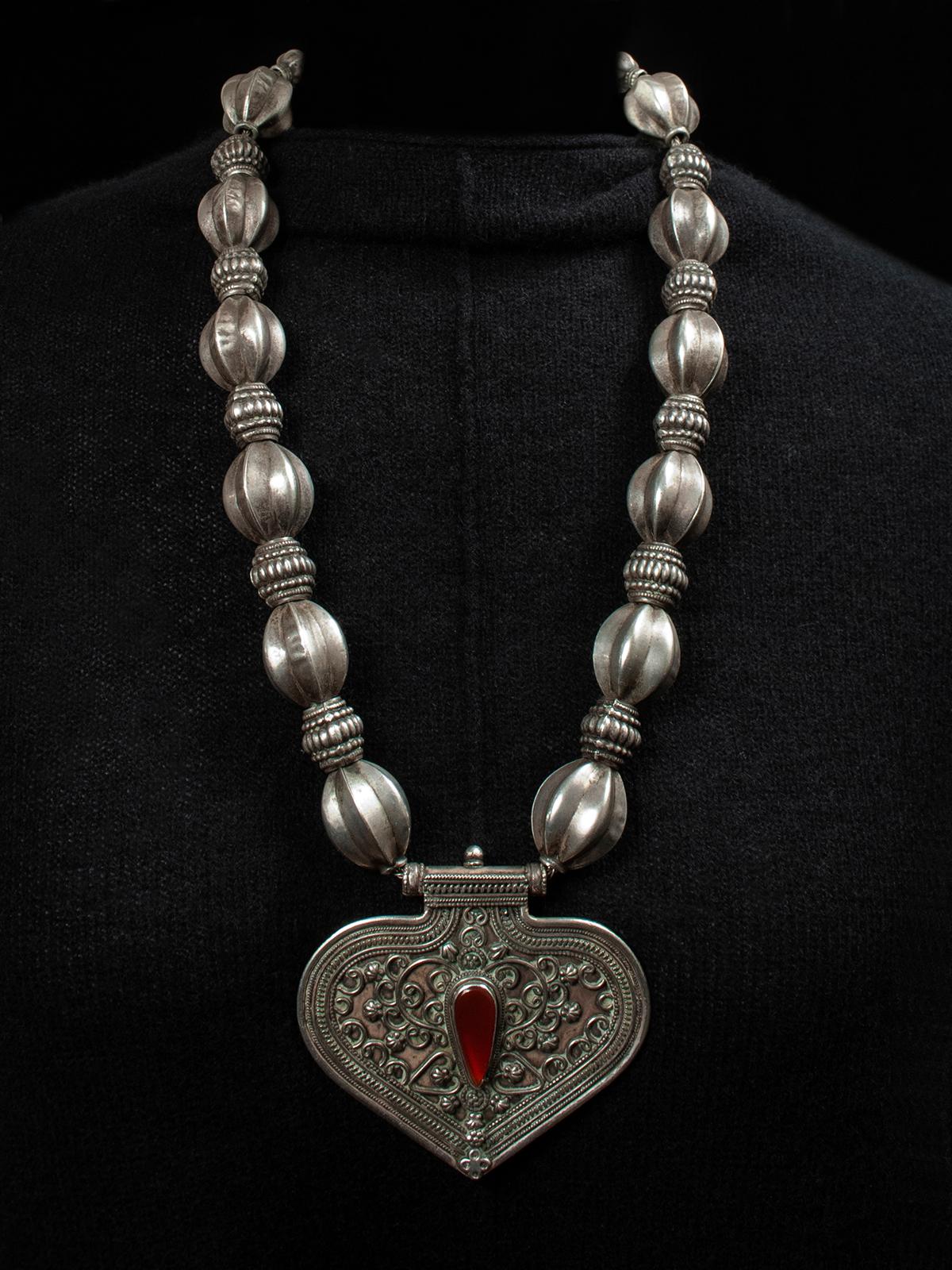 Early to Mid-20th Century Turkoman Silver necklace, Central Asia

A beautiful heart-shaped pendant with filigree design on the surface and a center teardrop of beveled glass or carnelian is strung on a braided chain with beautiful old silver