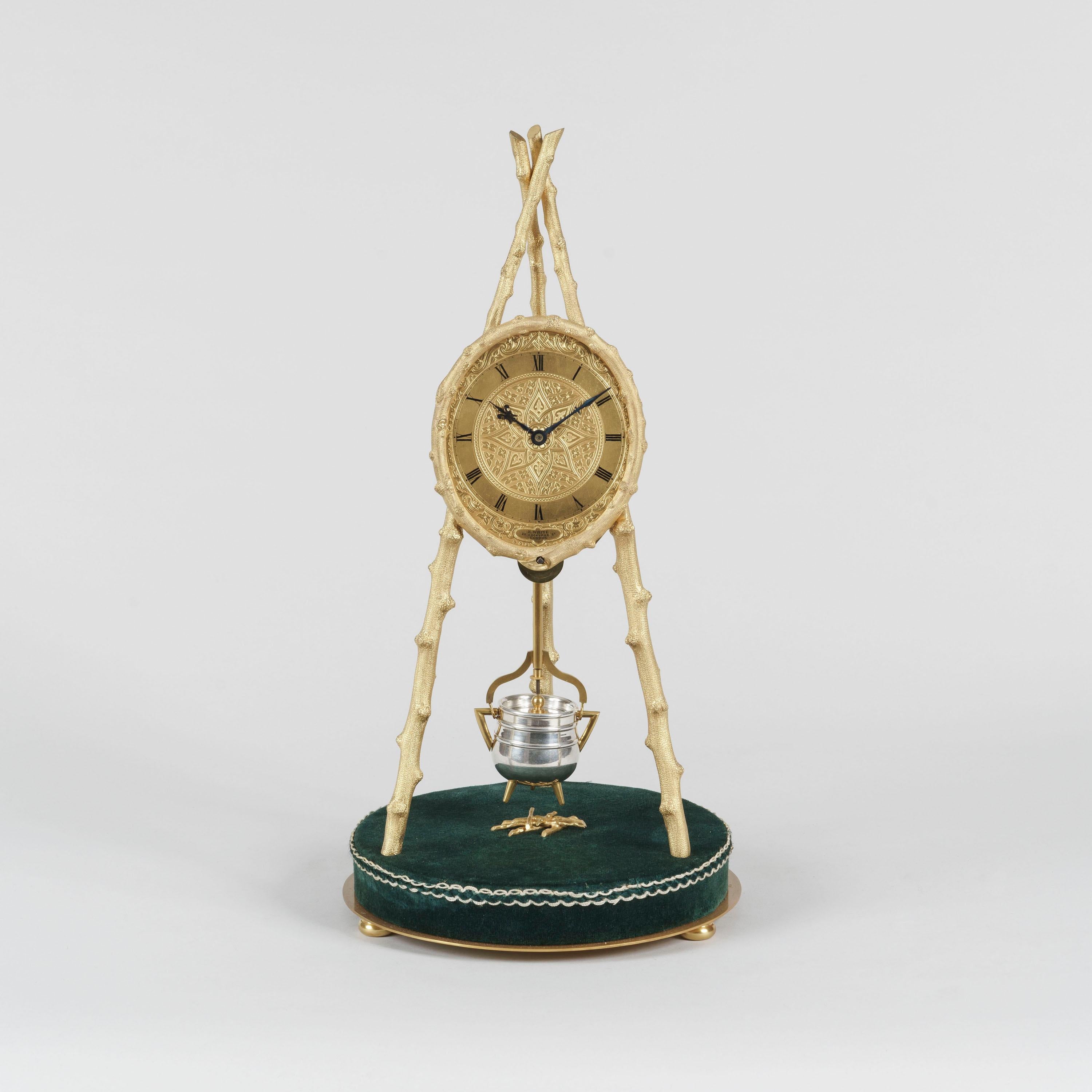 An extraordinary rustic tripod table clock
by Thomas Cole
Retailed by E. White of London

The circular green velvet-clad base supporting three equidistantly spaced brass imitation logs, from which the clock and its mechanism are suspended;
